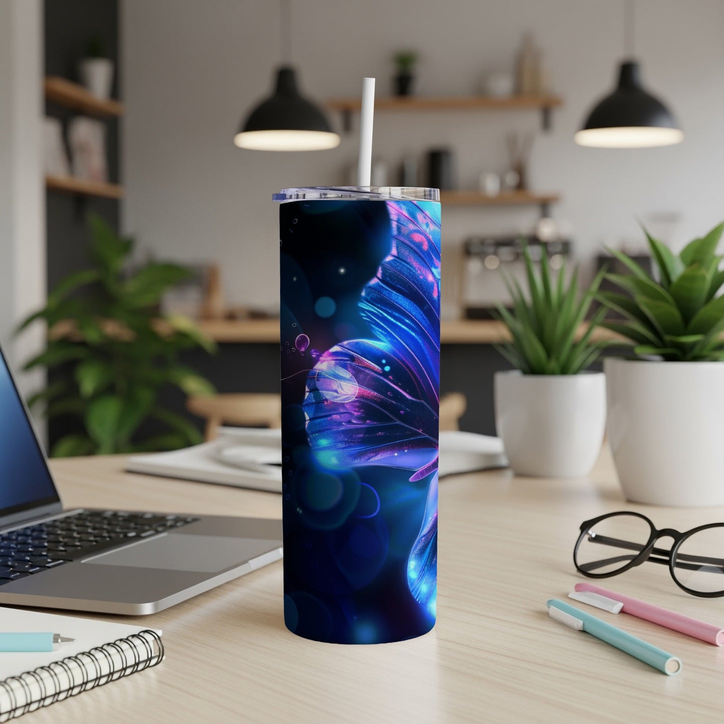 Blue butterfly tumbler with straw on a wooden desk.