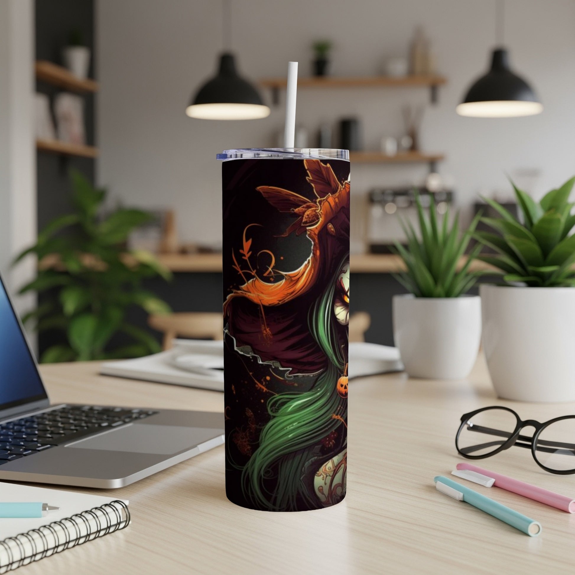 Tall tumbler with witch and pumpkin design, straw inserted.