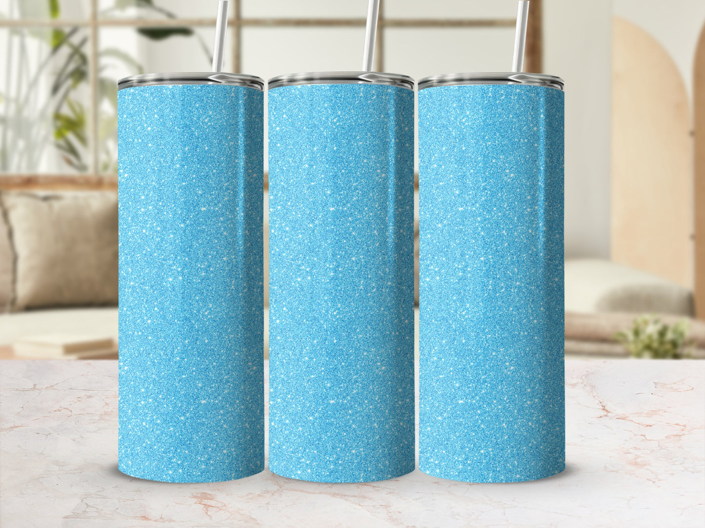 Three blue glitter tumblers with silver lids and straws stand side by side.