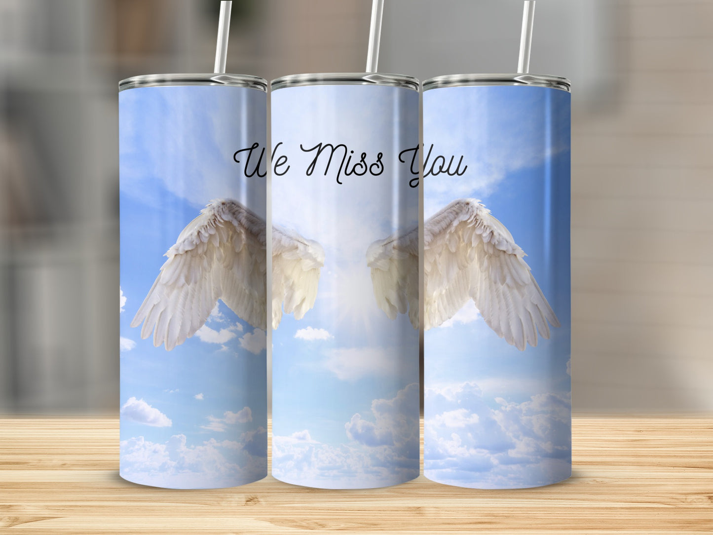 Angel wings with "We Miss You" text on a bright sky background.