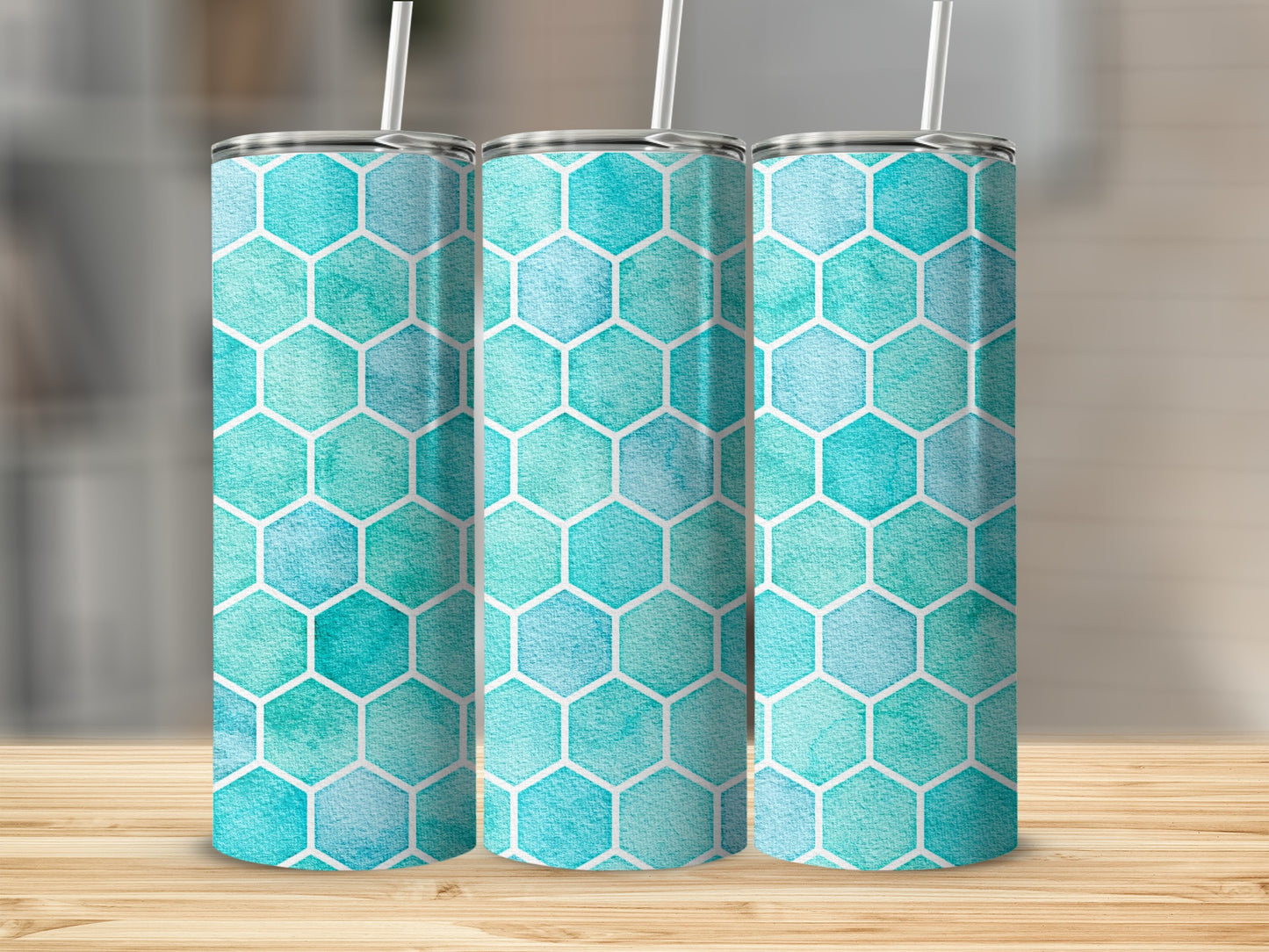 Three tumblers with a teal and blue hexagonal watercolor pattern stand on a wooden surface.