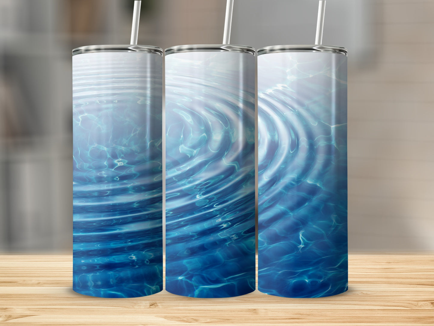 Three tumblers with rippling water design on wooden surface.