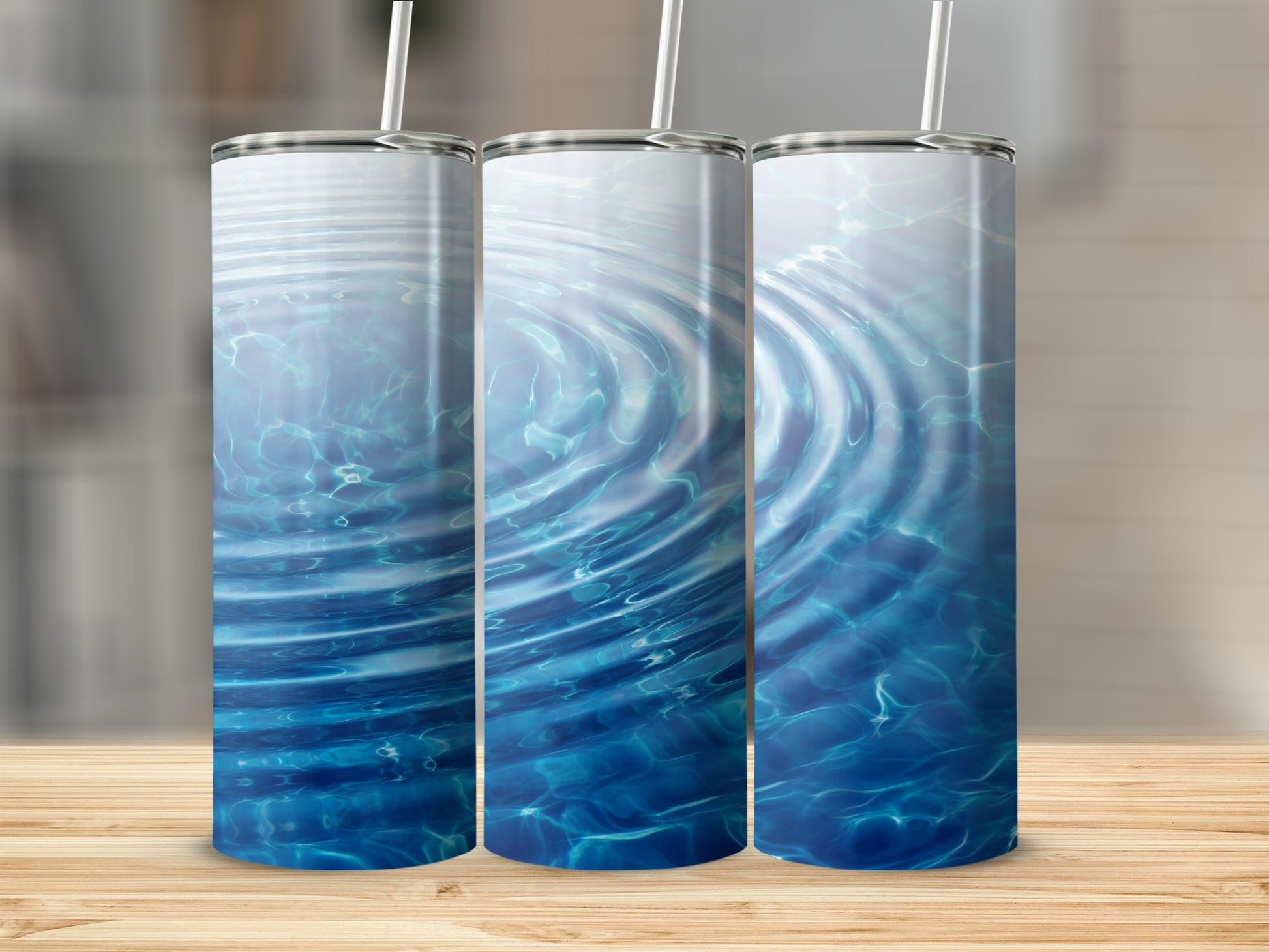 Three tumblers with rippling water design on wooden surface.