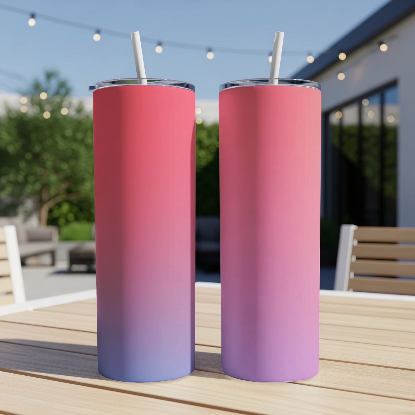 Two tumblers with pink-to-purple gradient and white straws on a wooden table.