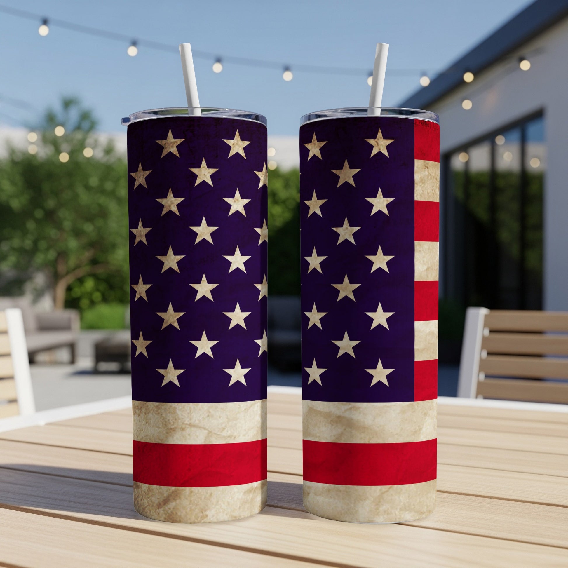 Two American flag tumblers with straws on a wooden table.