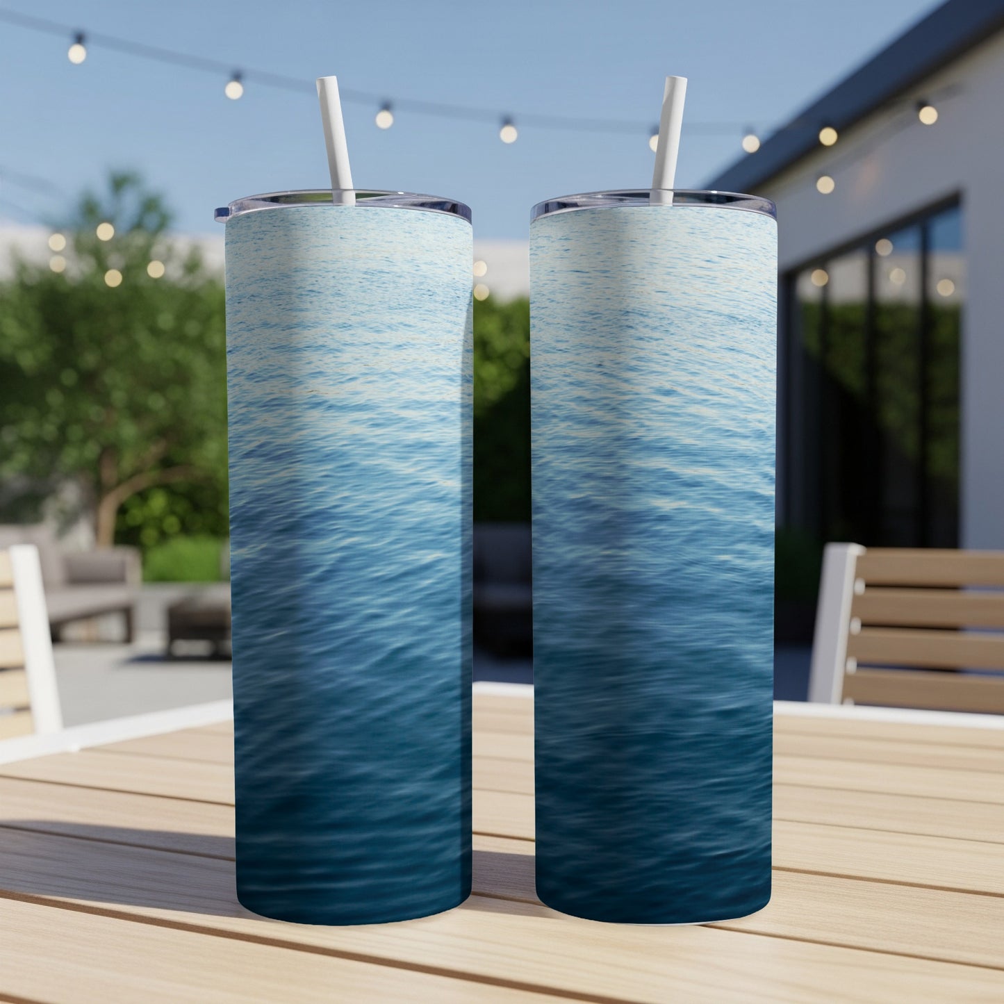 Two tall tumblers with a blue water ripple design sit on a wooden table.