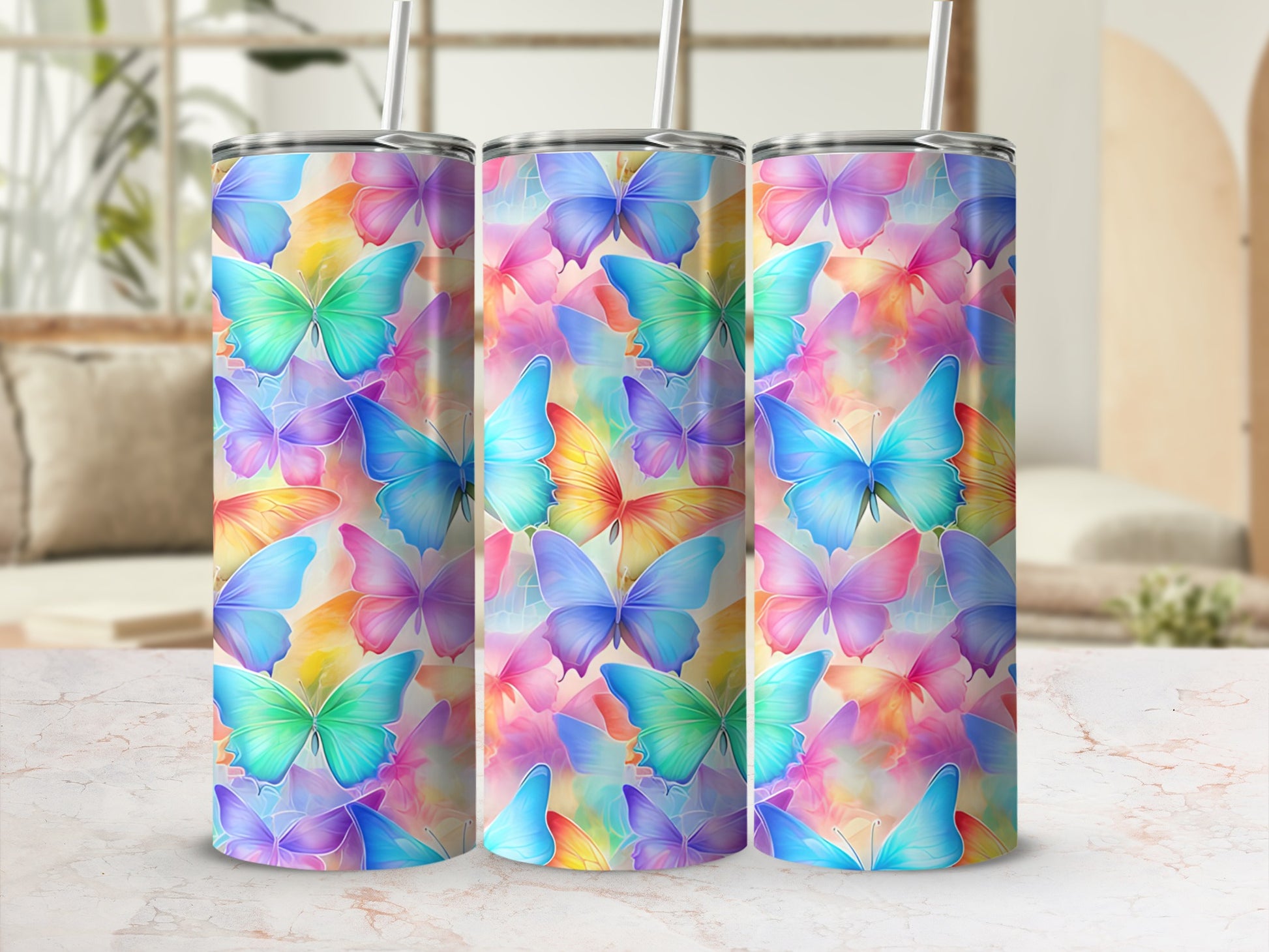 Three colorful butterfly-patterned tumblers with straws, arranged side-by-side.