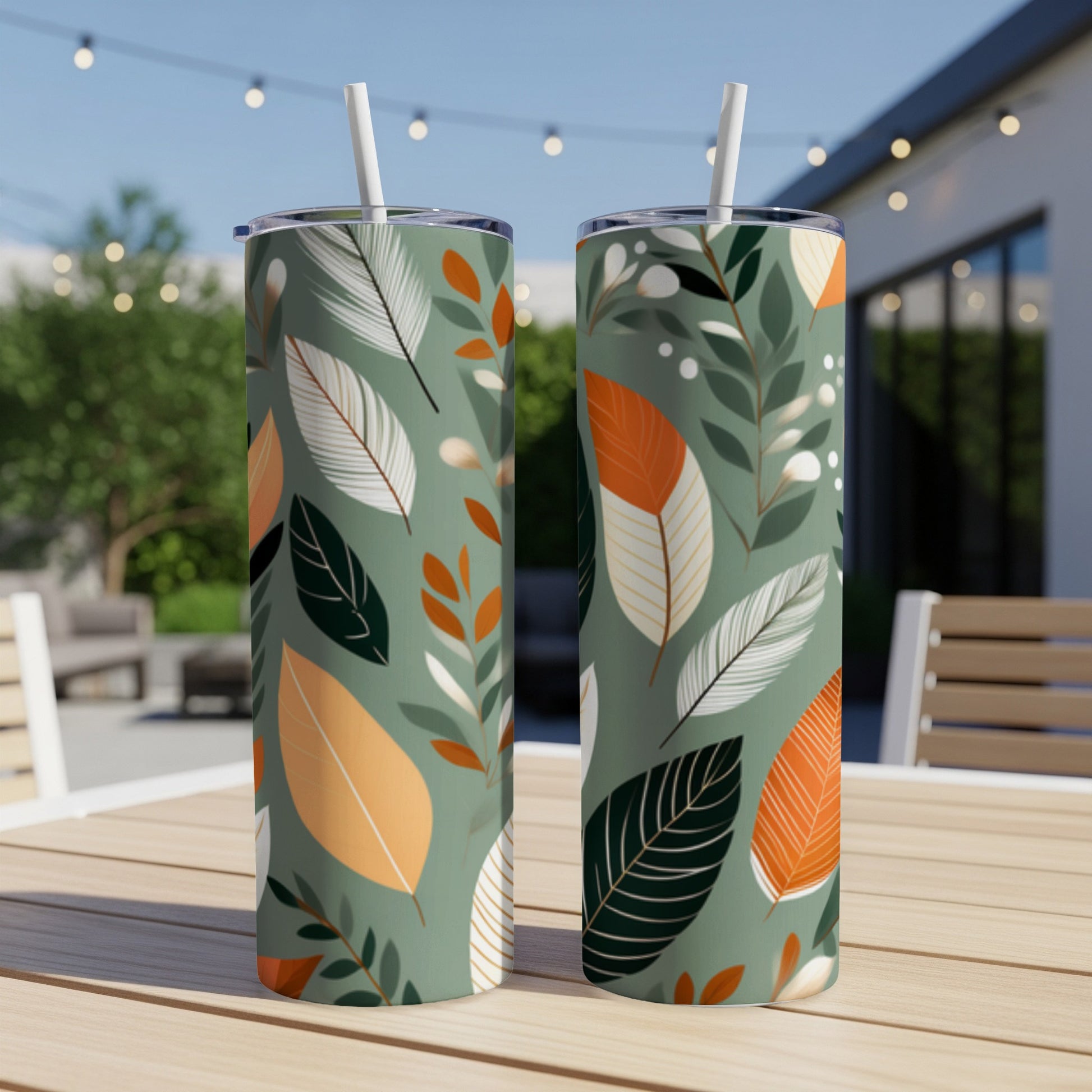 Two tumblers with green background and white, orange, and dark green leaf pattern.