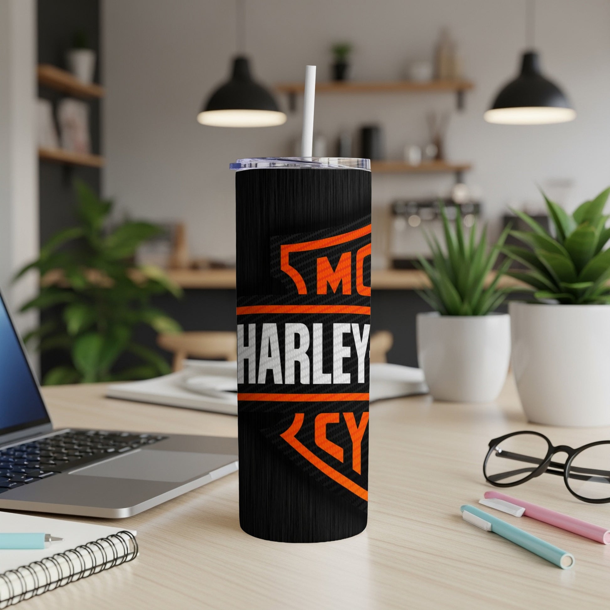 Tumbler with orange and white Harley-Davidson logo on textured black surface.