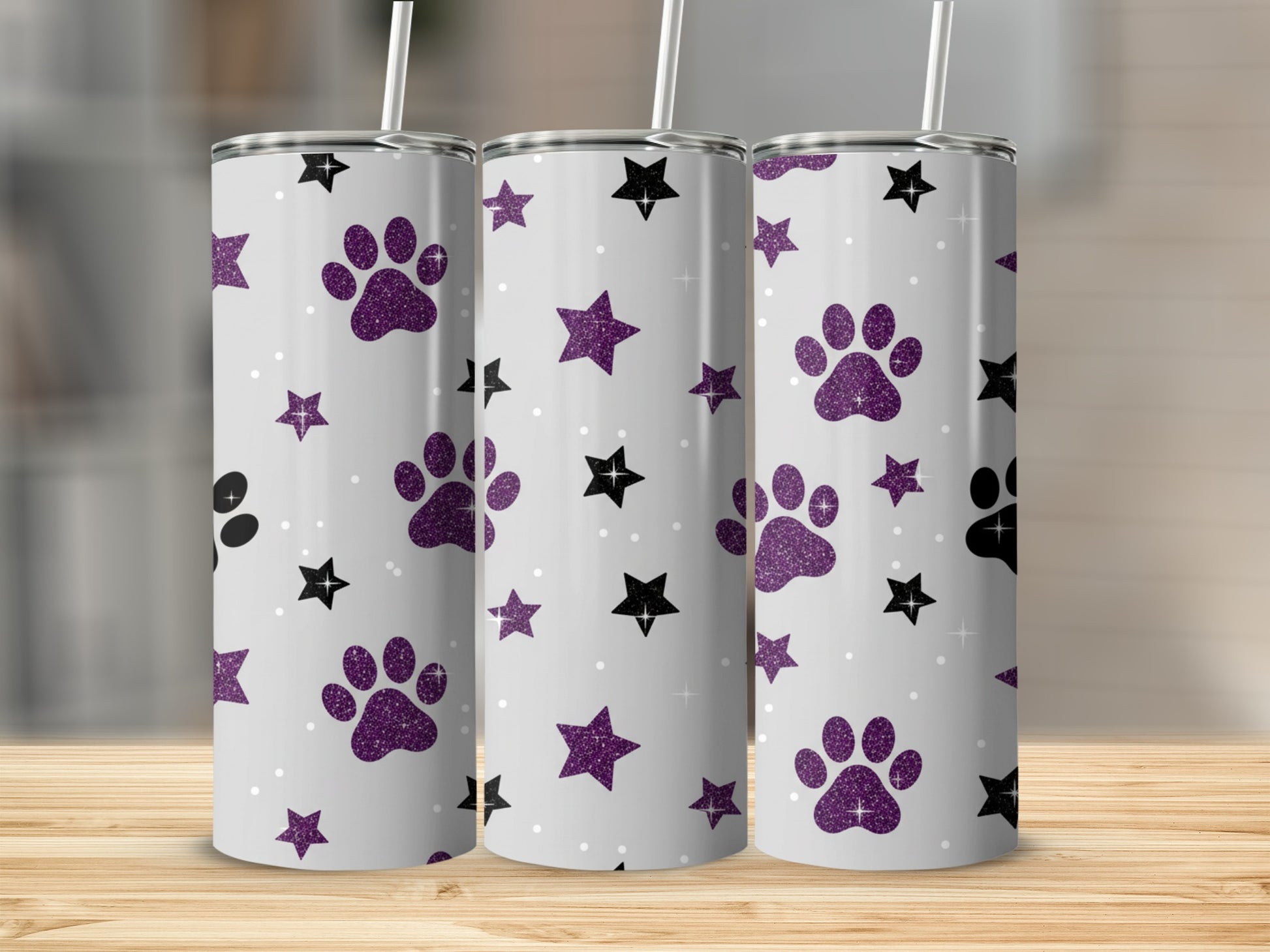 Three tumblers with purple glitter paw prints and stars on a light gray background.