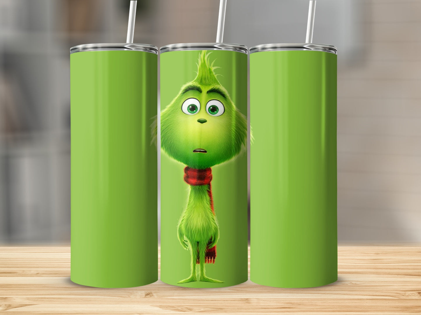 The Grinch wearing a red scarf on a green tumbler.