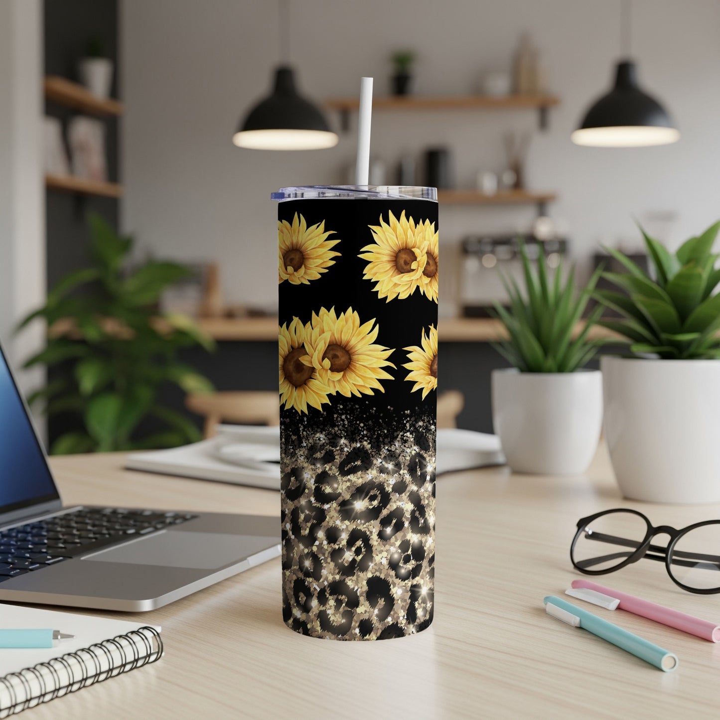 Tall tumbler with sunflowers and leopard print design on a desk.