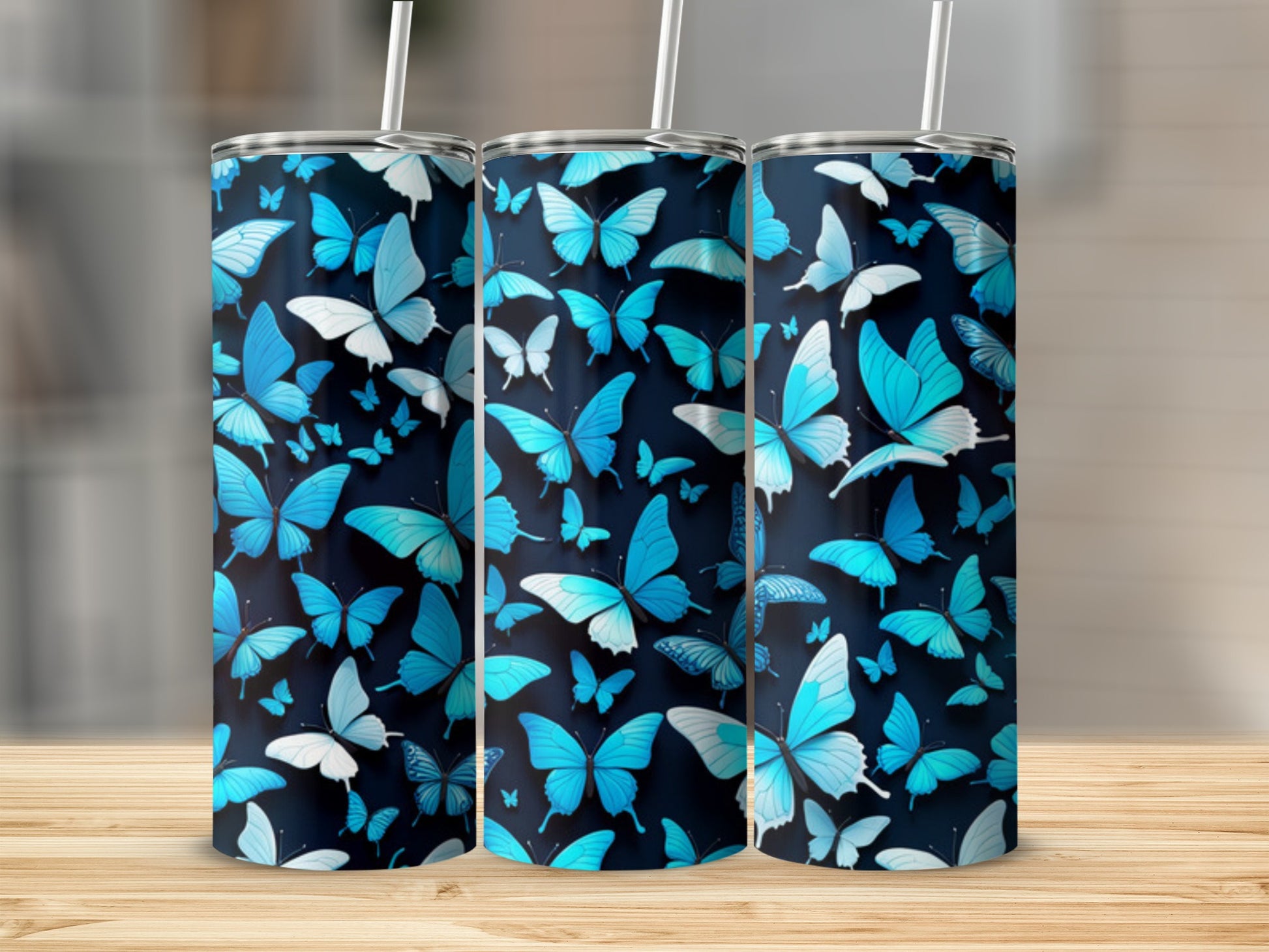 Three tumblers with a blue butterfly pattern on a wooden surface.