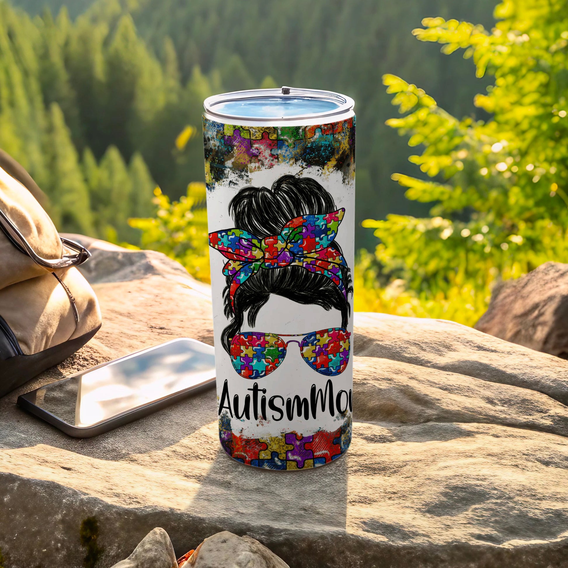 Tumbler with autism puzzle pattern, sunglasses, and "Autism Mom" text.