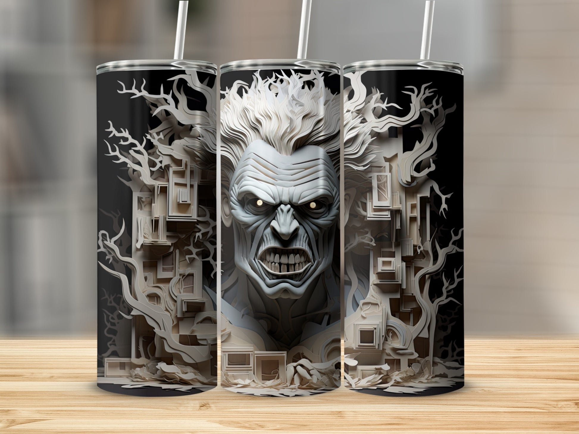 Three tumblers feature a monstrous face with glowing eyes and a forest of paper-cut trees.