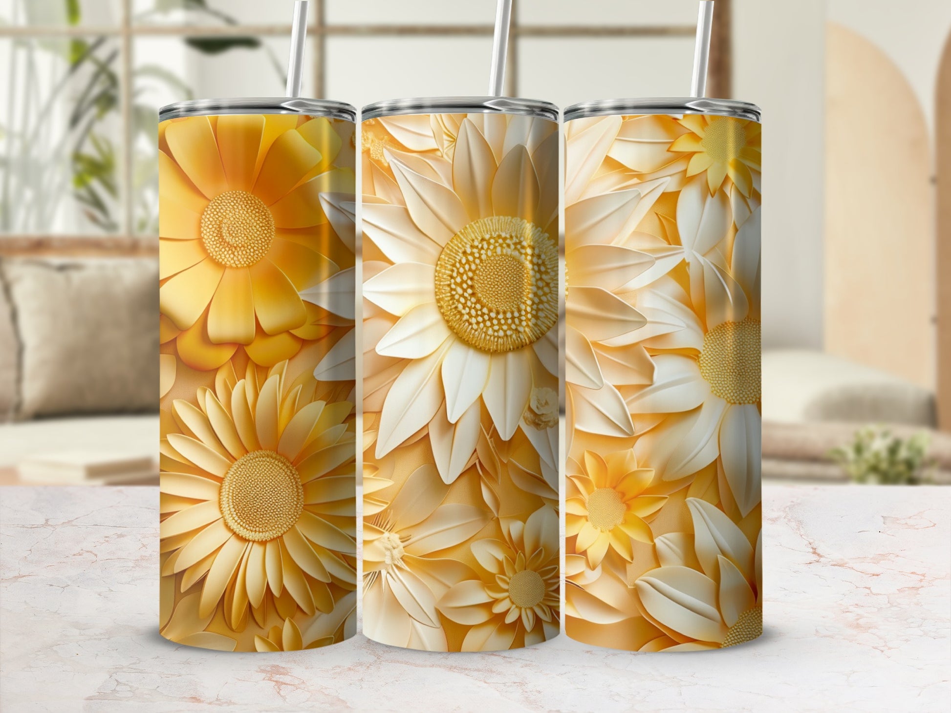 Three yellow and white floral tumblers with straws on a marble surface.