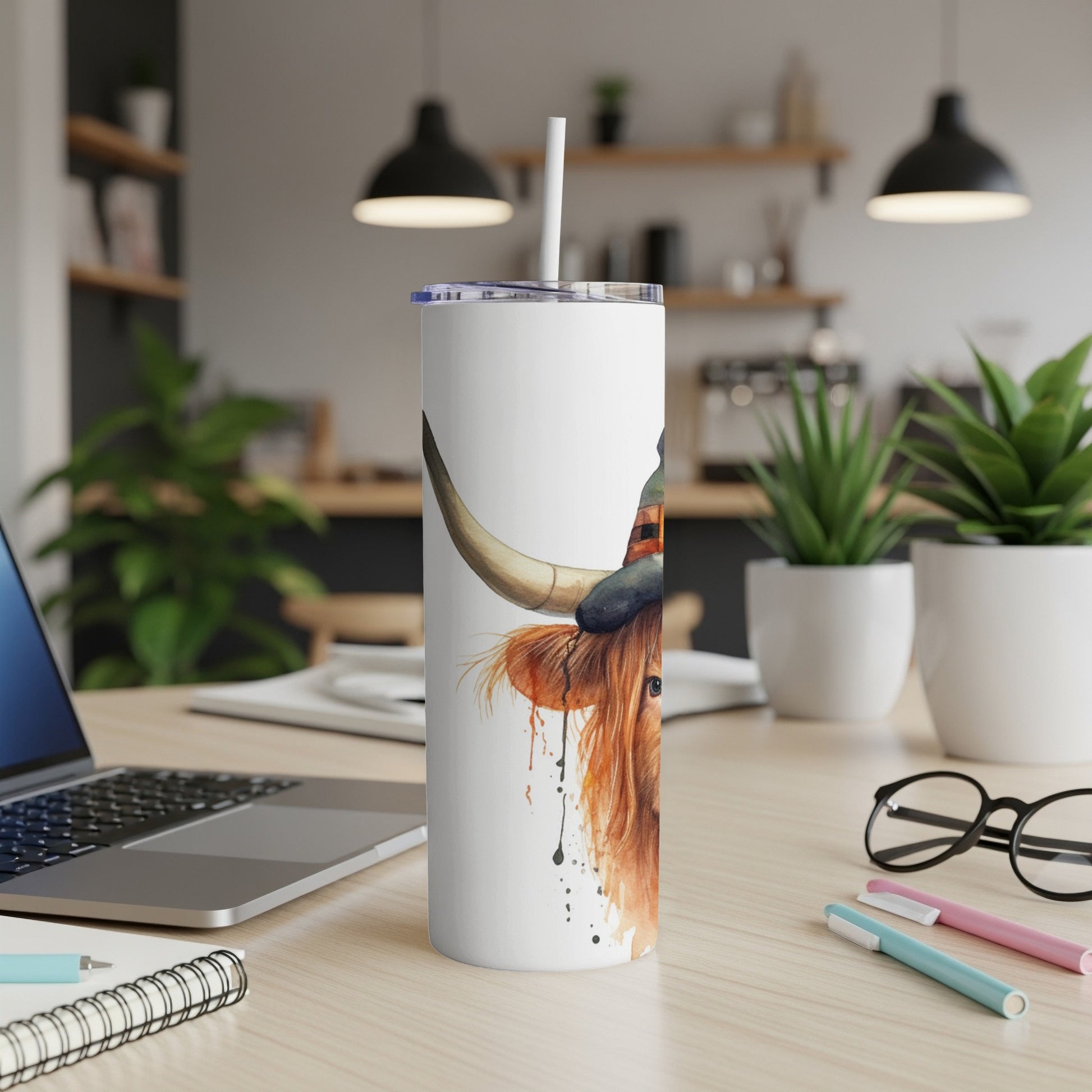 White tumbler with highland cow wearing a witch hat, watercolor style.