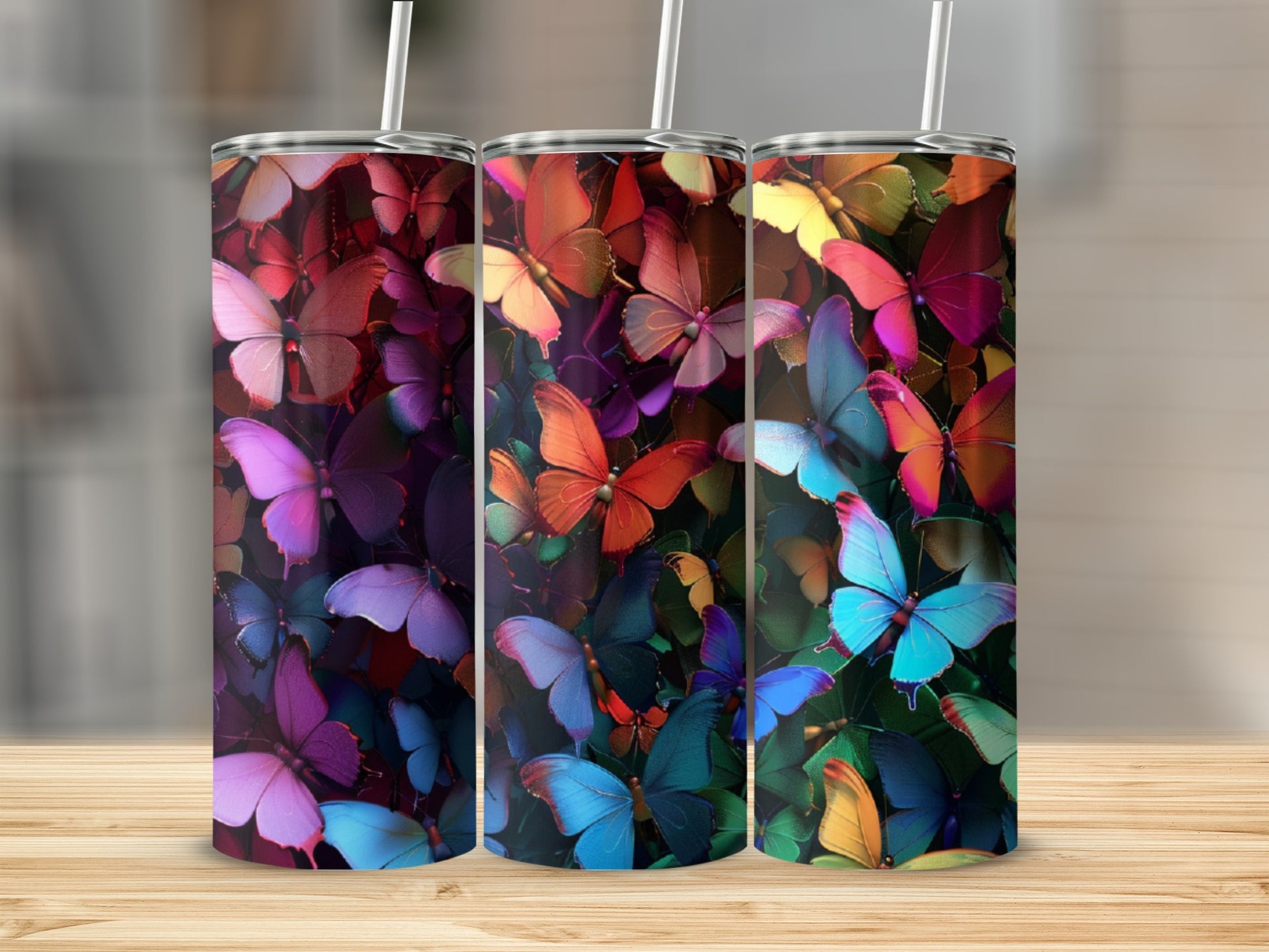 Three tumblers with vibrant butterfly designs in various colors.