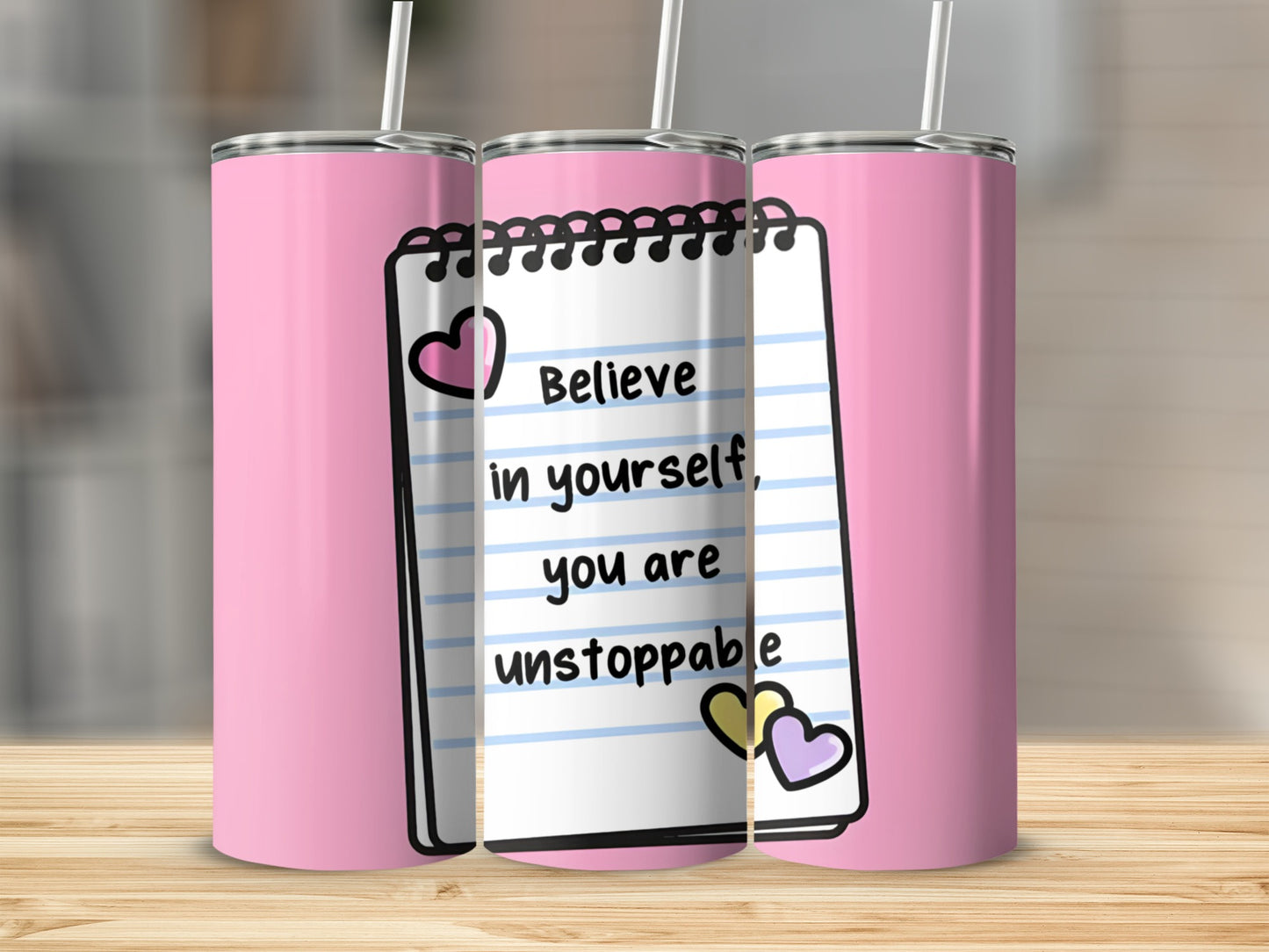 Pink tumbler with notebook design and "Believe in yourself, you are unstoppable" text.
