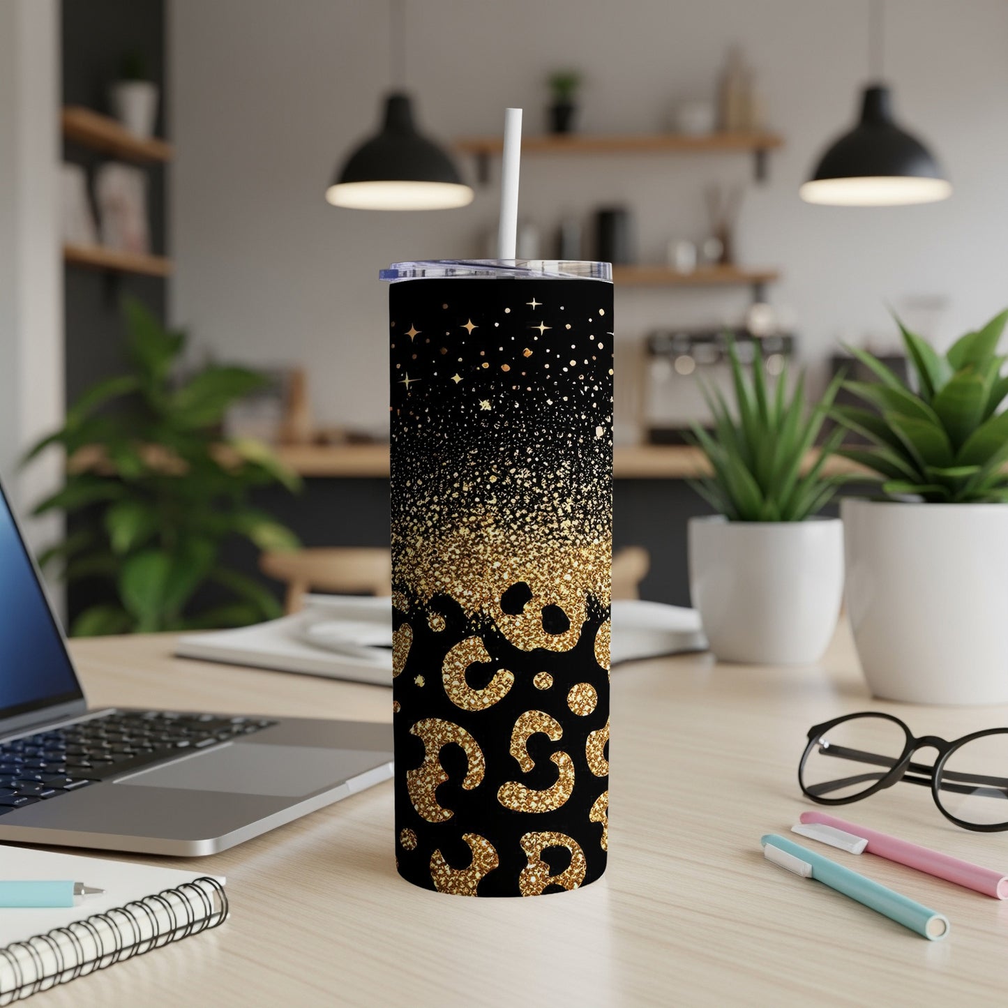 Black tumbler with gold glitter and leopard print, on a desk.