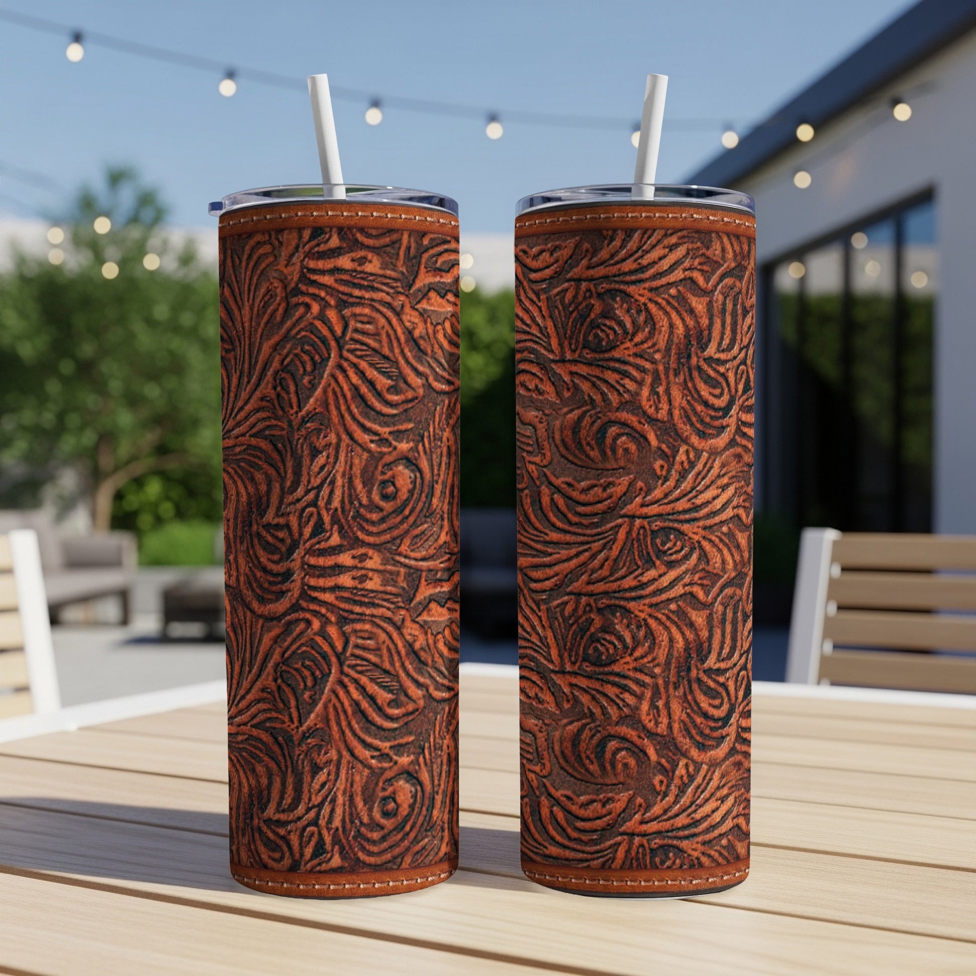 Two tall tumblers with ornate brown western leather tooling design.