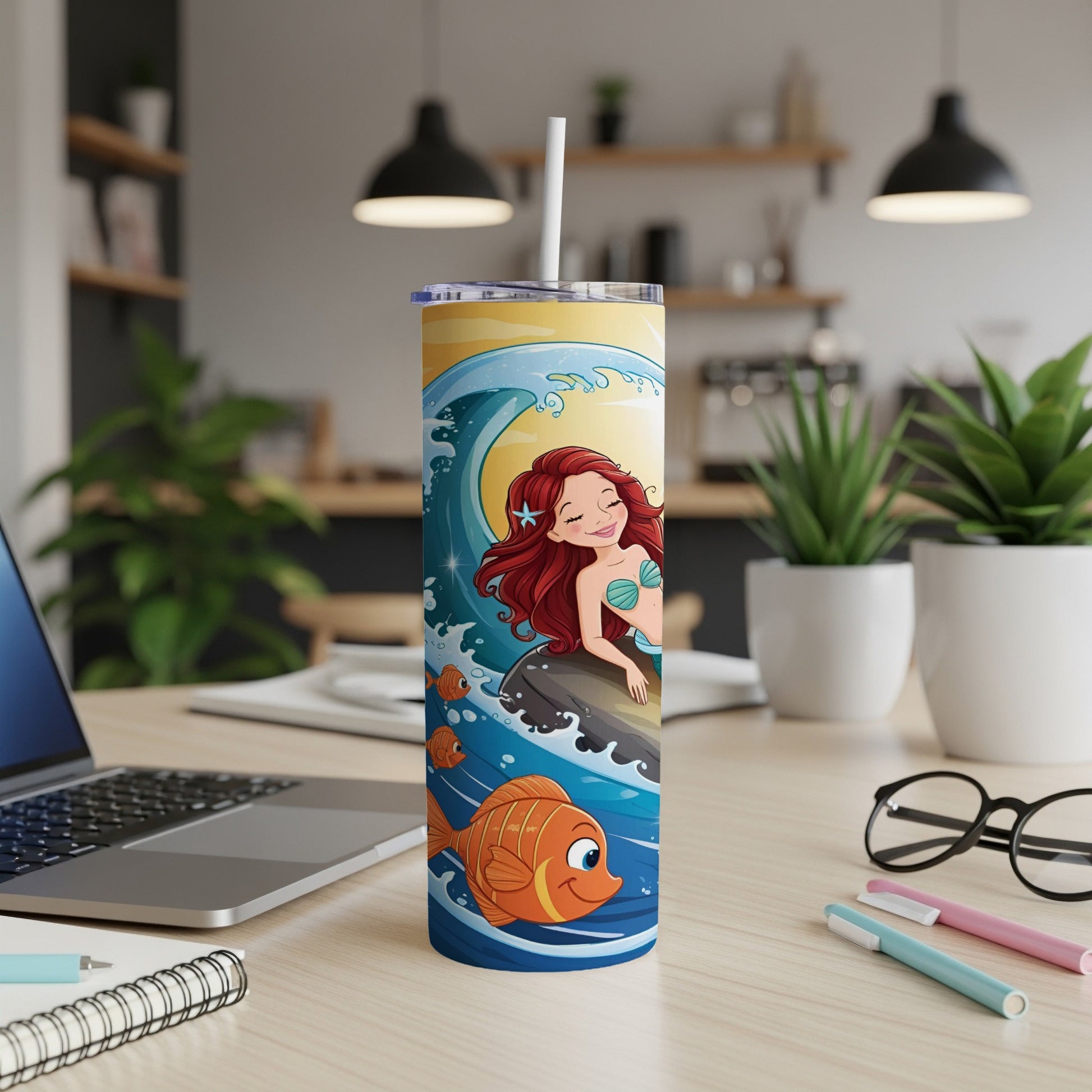 Mermaid and fish illustration on a blue and yellow patterned tumbler.