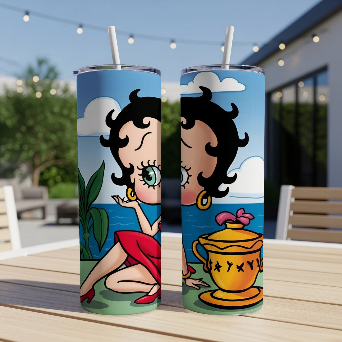 Betty Boop artwork on two stainless steel tumblers on a table.