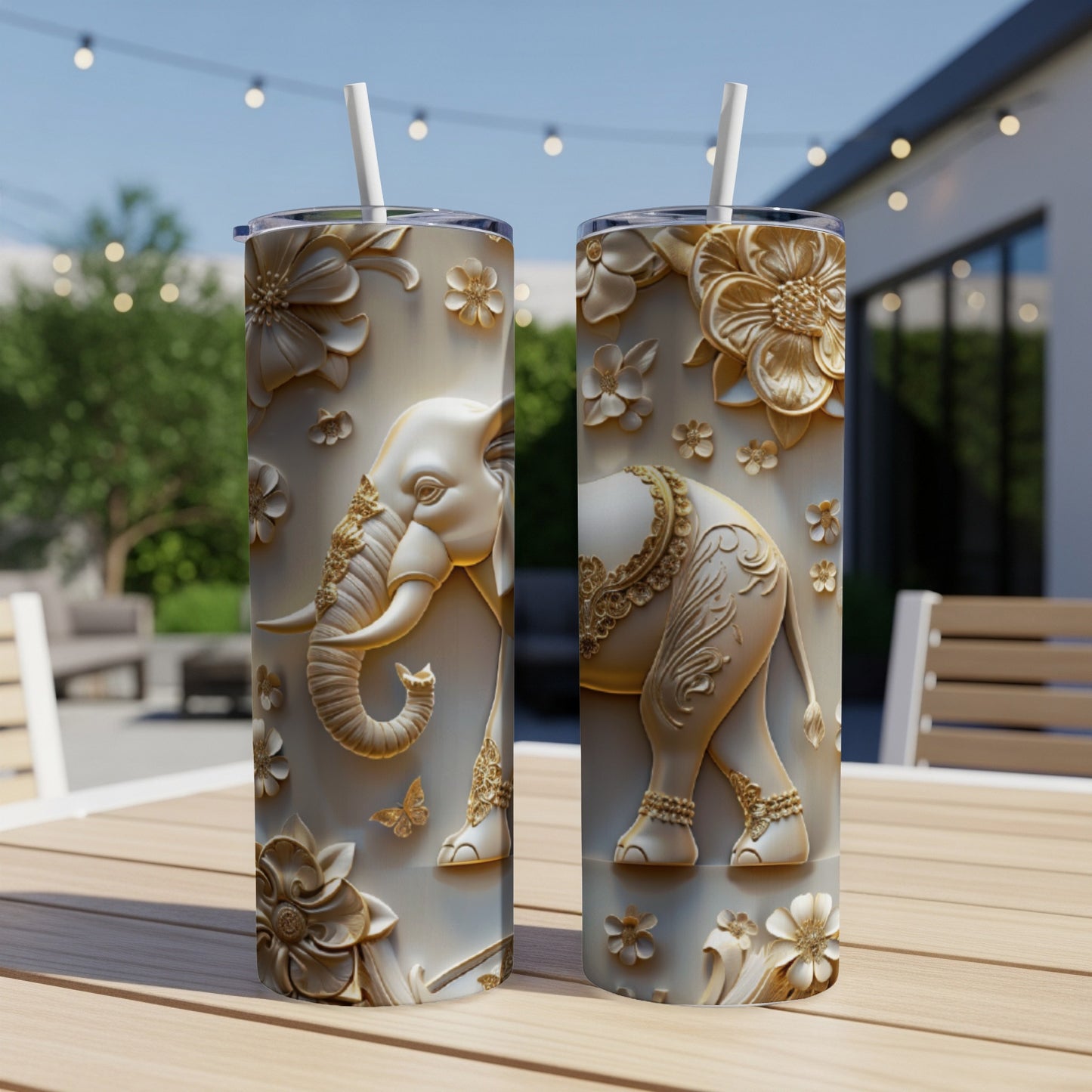 Two white tumblers with embossed elephant and floral designs, on a wooden table.