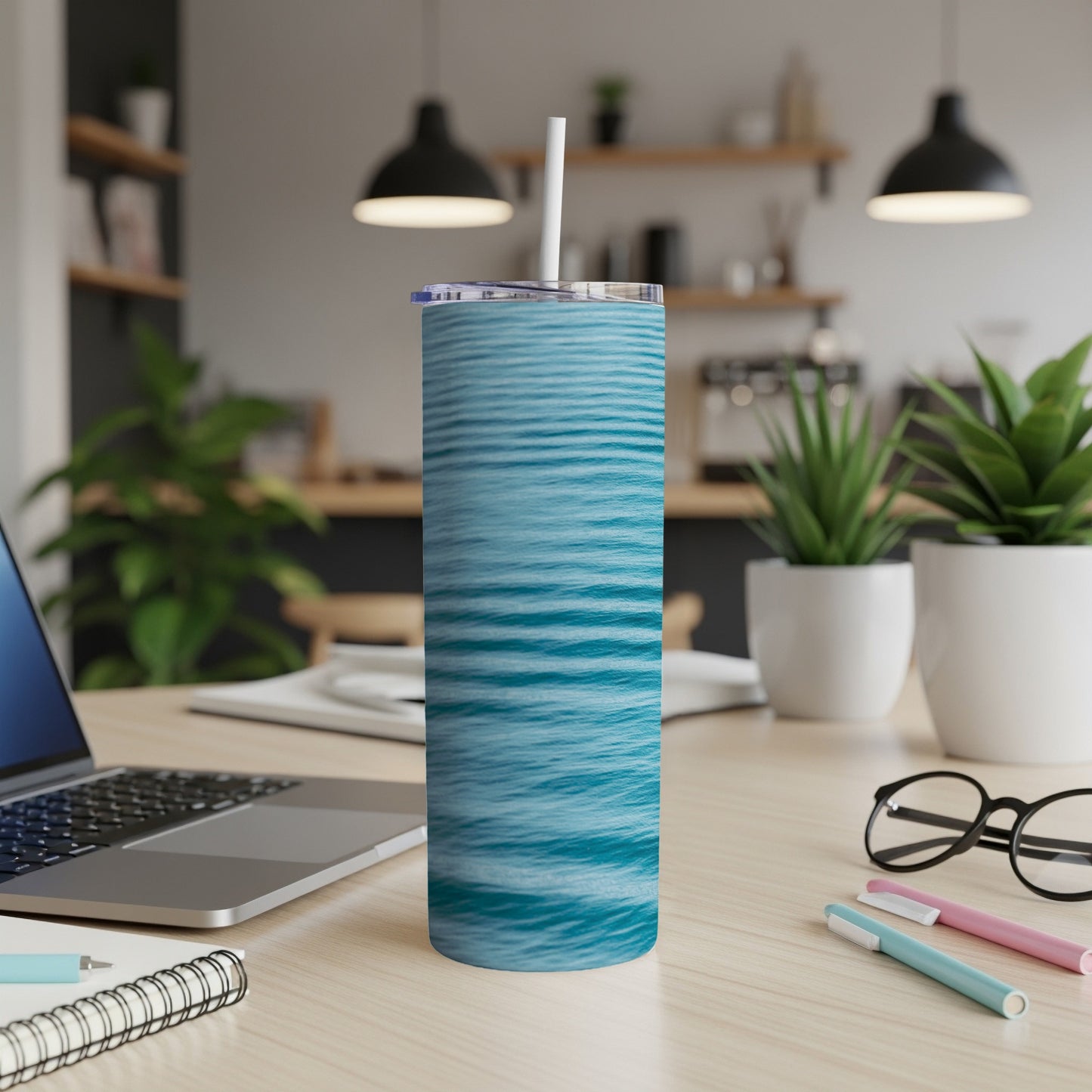 Blue rippled water pattern on a stainless steel tumbler with straw.
