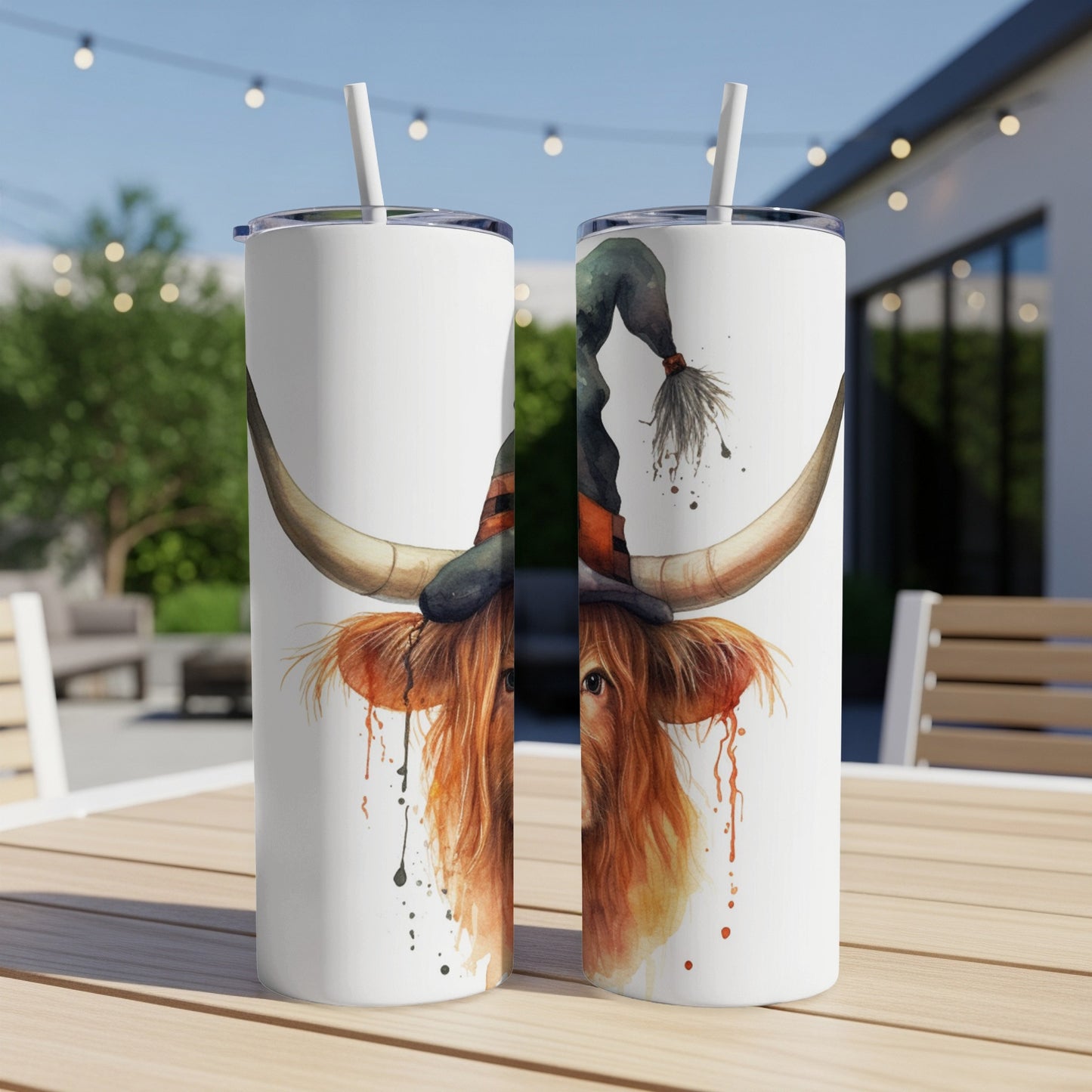 Highland cow wearing a witch hat, two tumblers on a table.