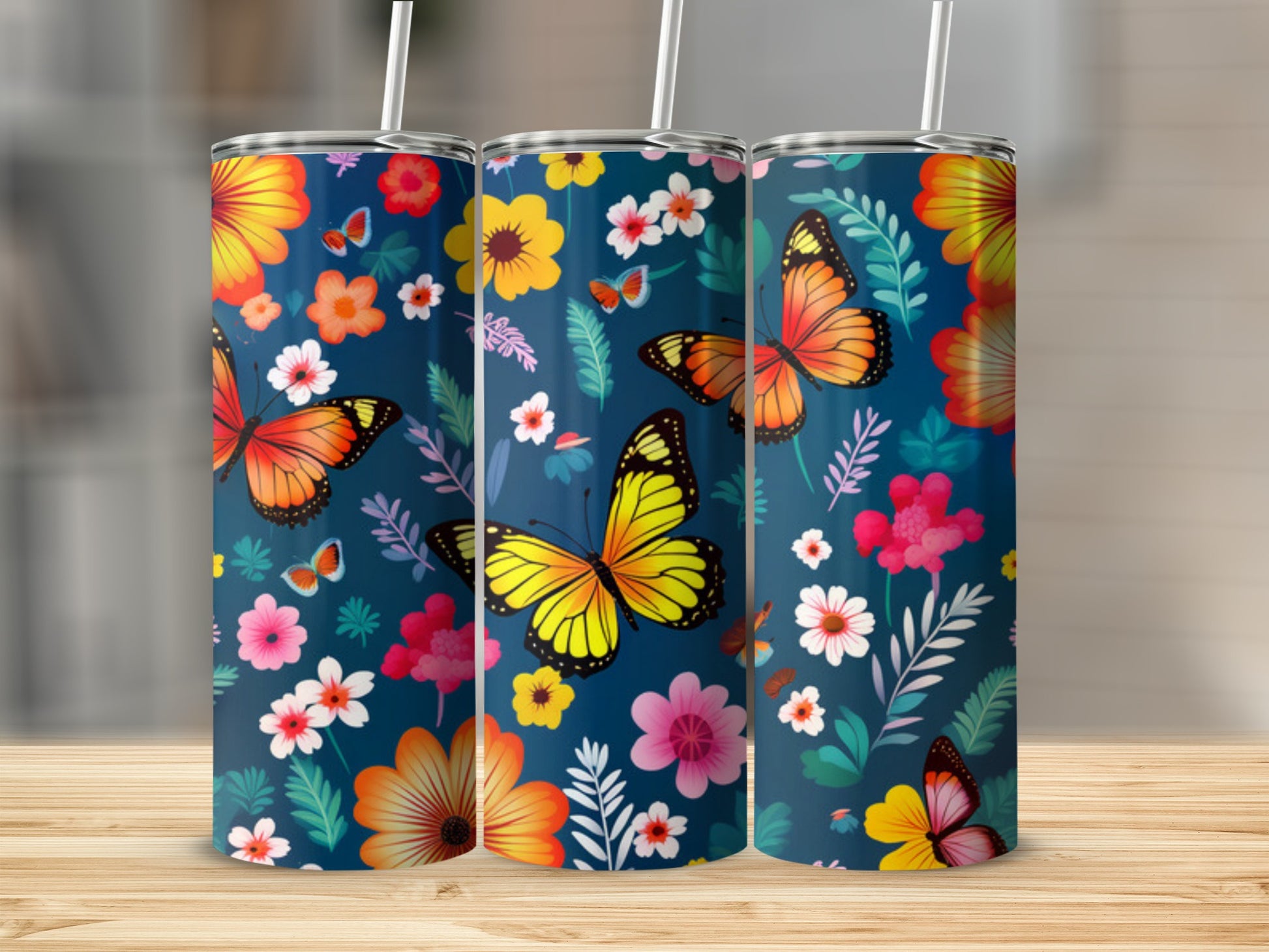 Three tumblers with a floral and butterfly design on a wooden surface.