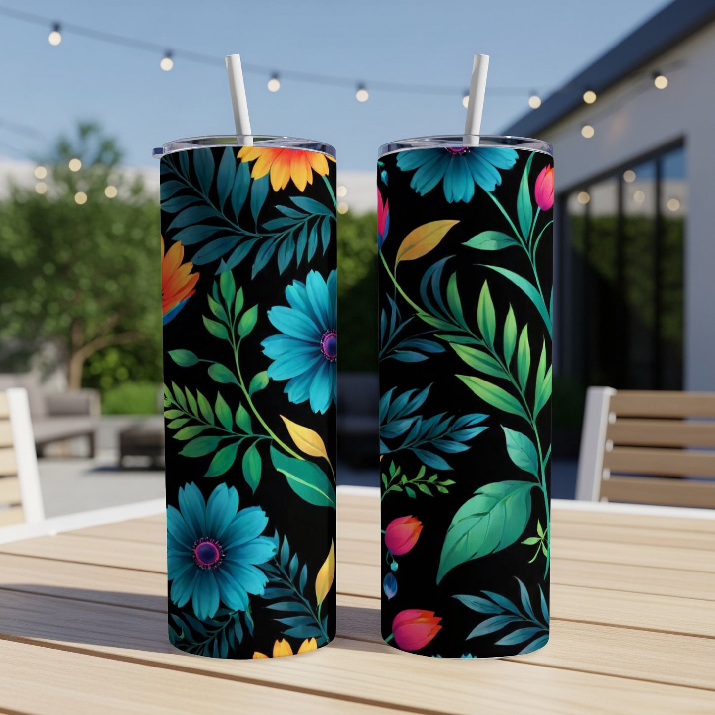 Two black tumblers with vibrant floral and leaf patterns, outdoors.