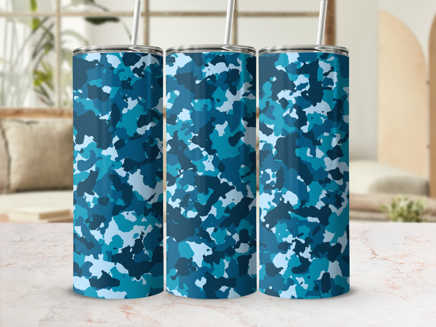 Three tumblers with blue camouflage pattern and metal straws.