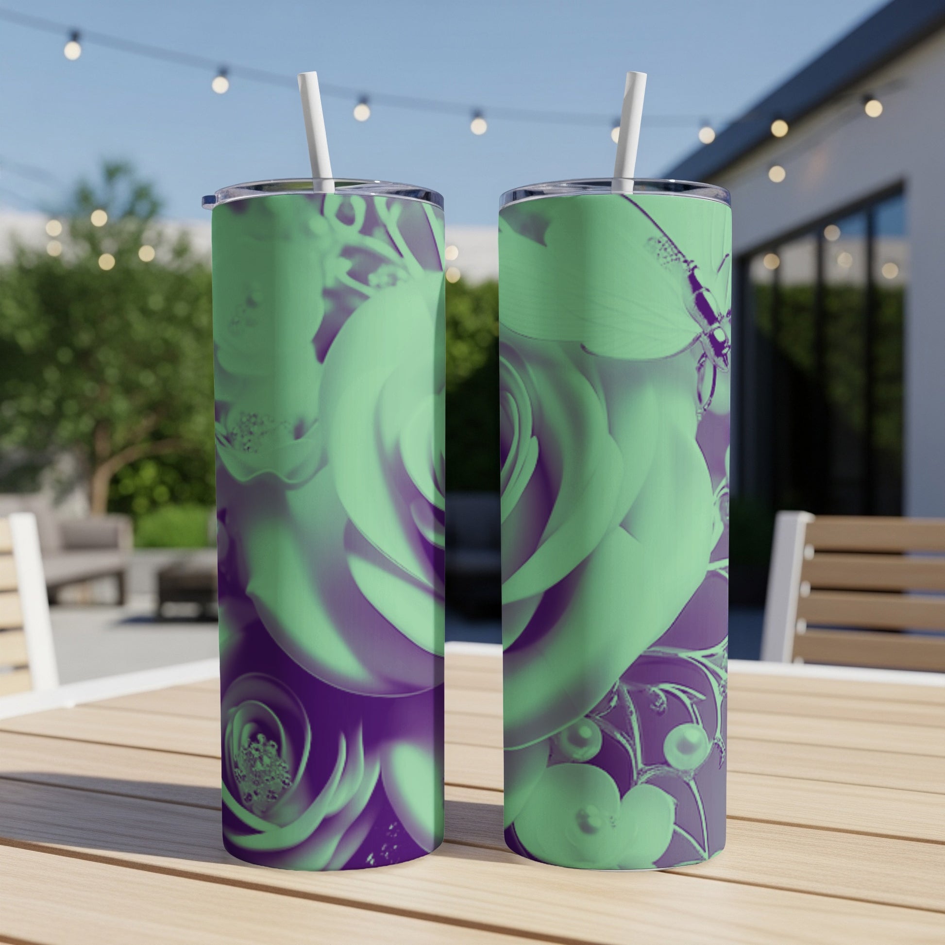 Two mint green tumblers with purple rose and butterfly designs on a table.