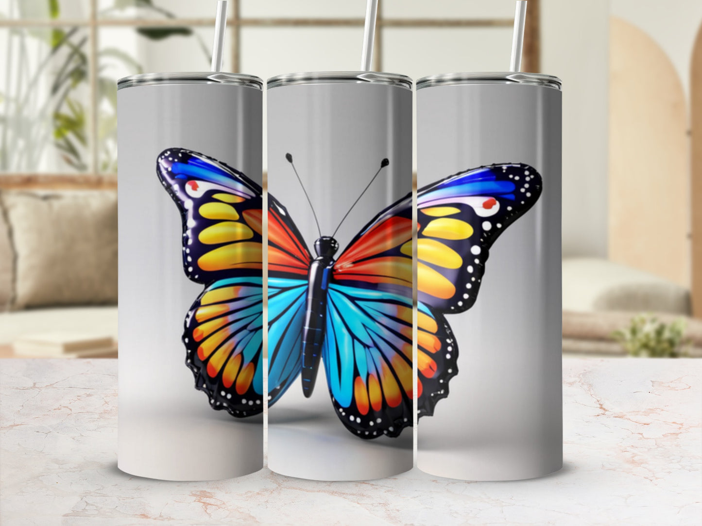 Butterfly design on three silver tumblers with straws.