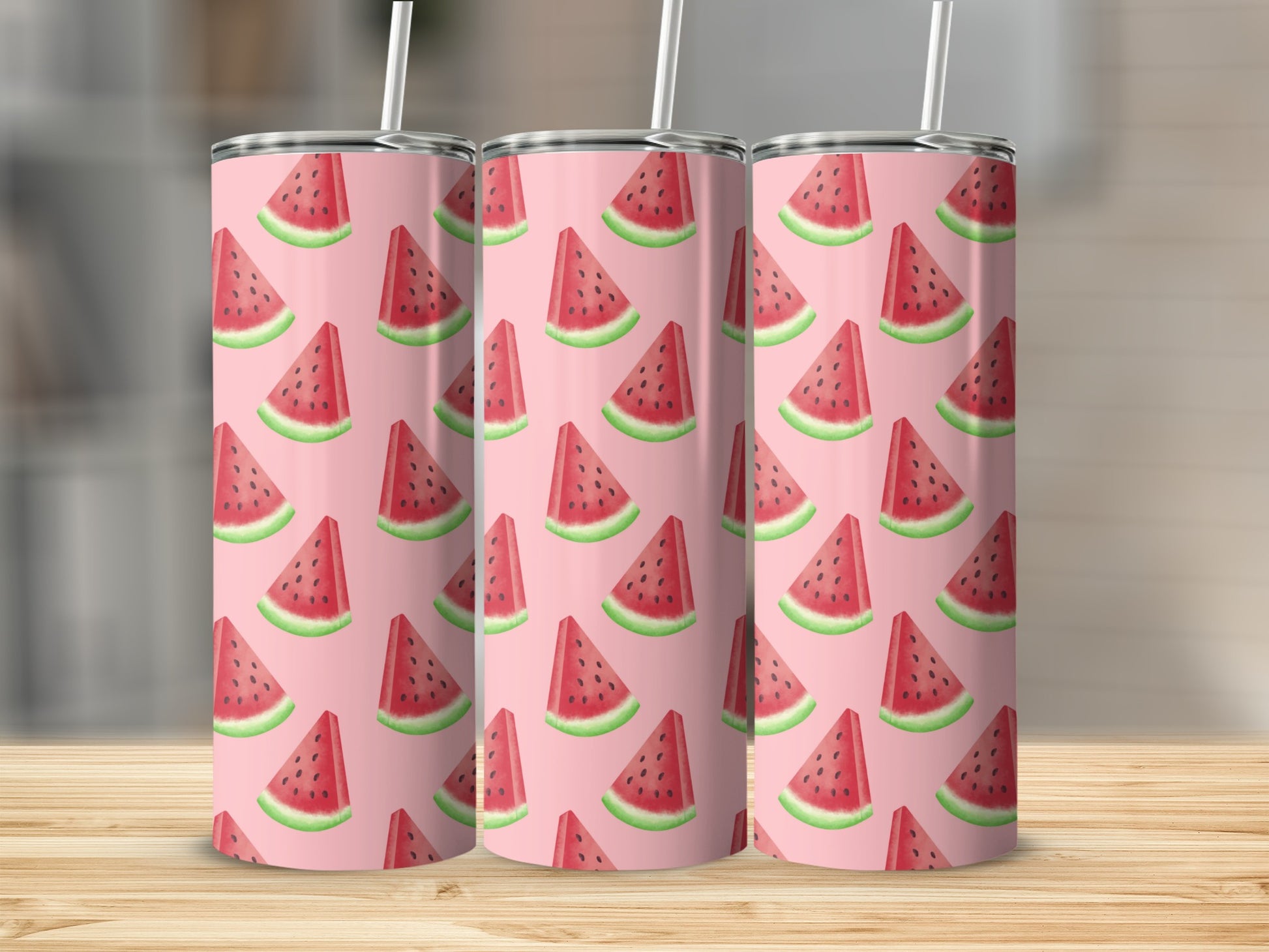 Three tumblers with a repeating pattern of watermelon slices on a wooden surface.