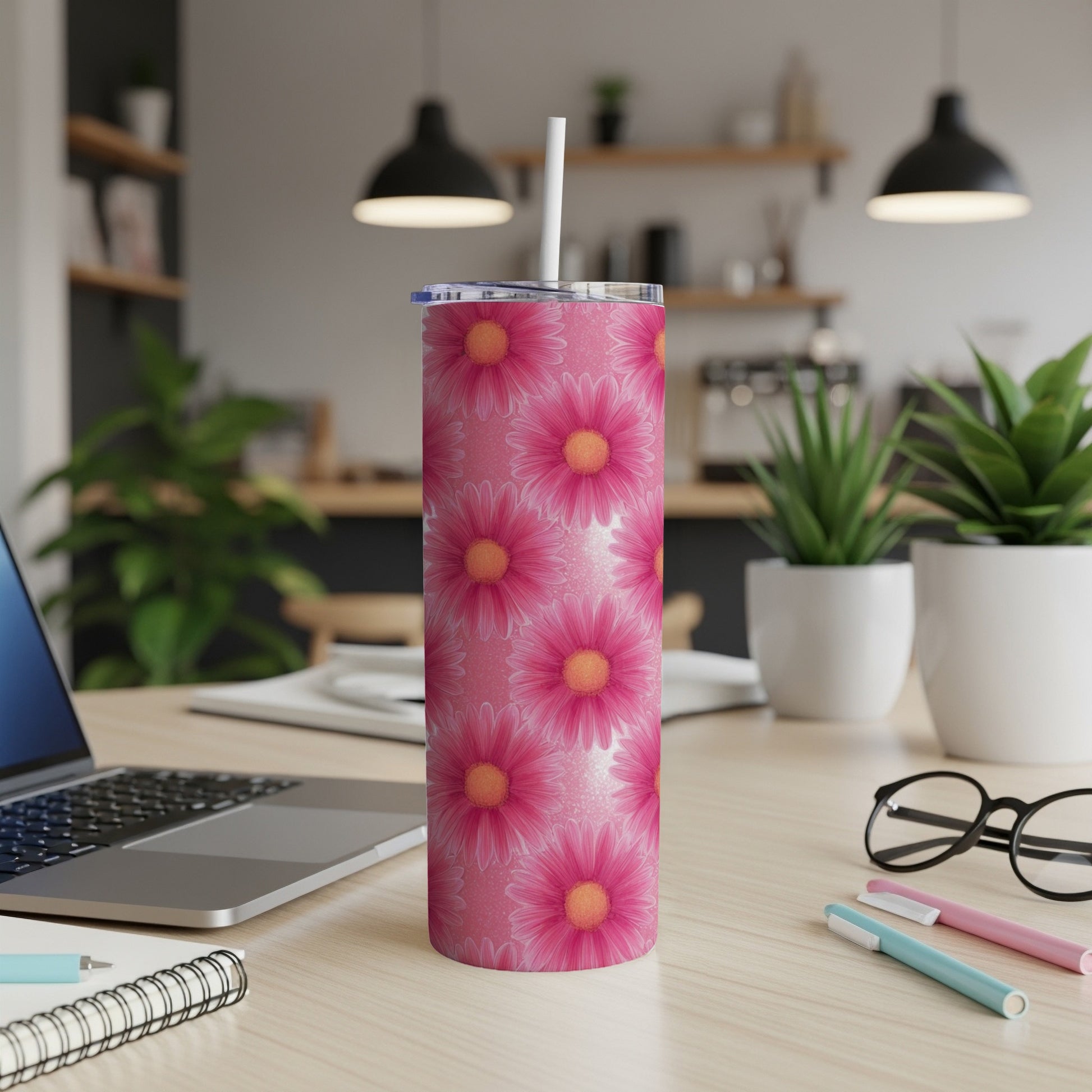 Pink floral tumbler with straw on a desk.