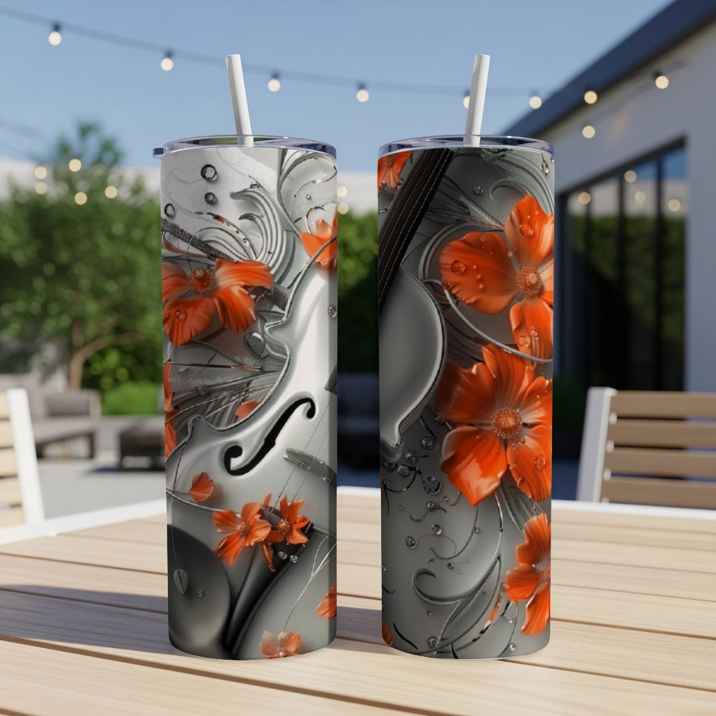Two tumblers with floral and violin design on an outdoor table.