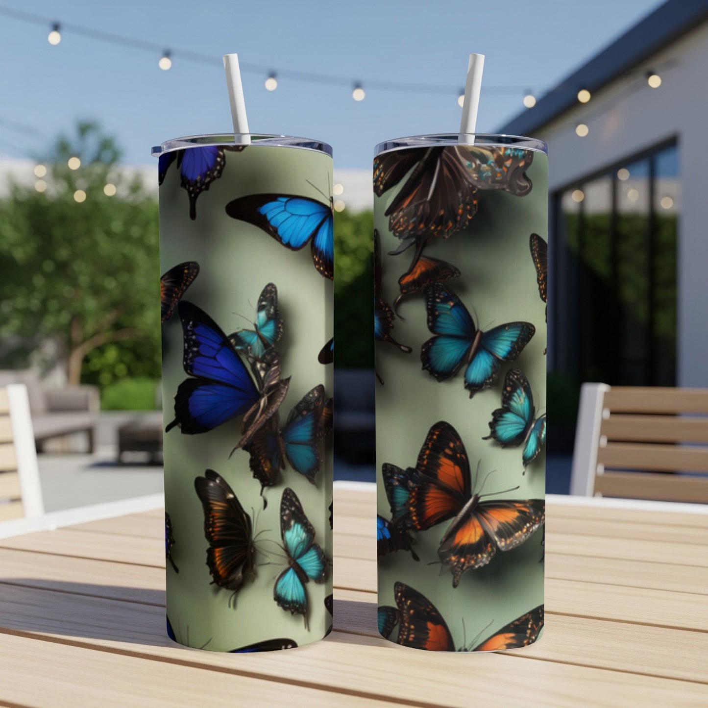 Two tumblers with a pattern of colorful butterflies on a patio table.