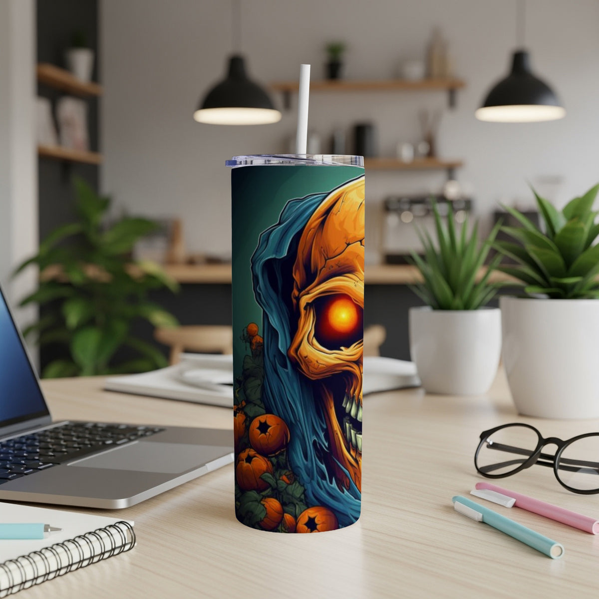 Tumbler with a skull, pumpkins, and a blue hood design.