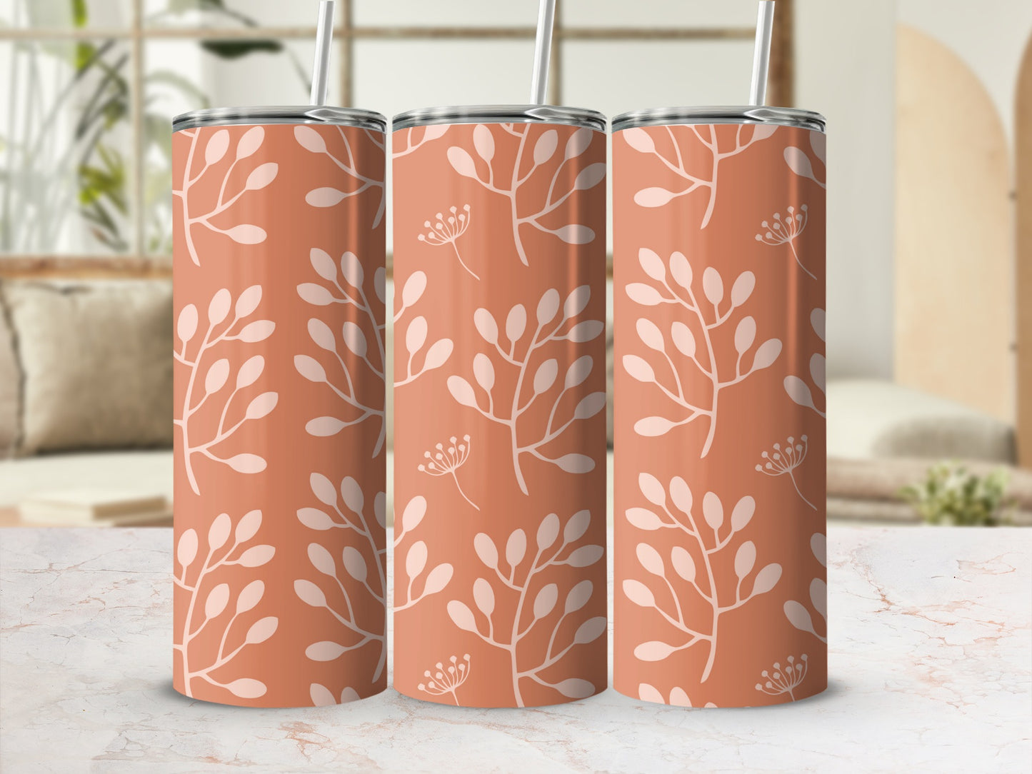 Three coral tumblers with a light floral pattern, one with a straw.