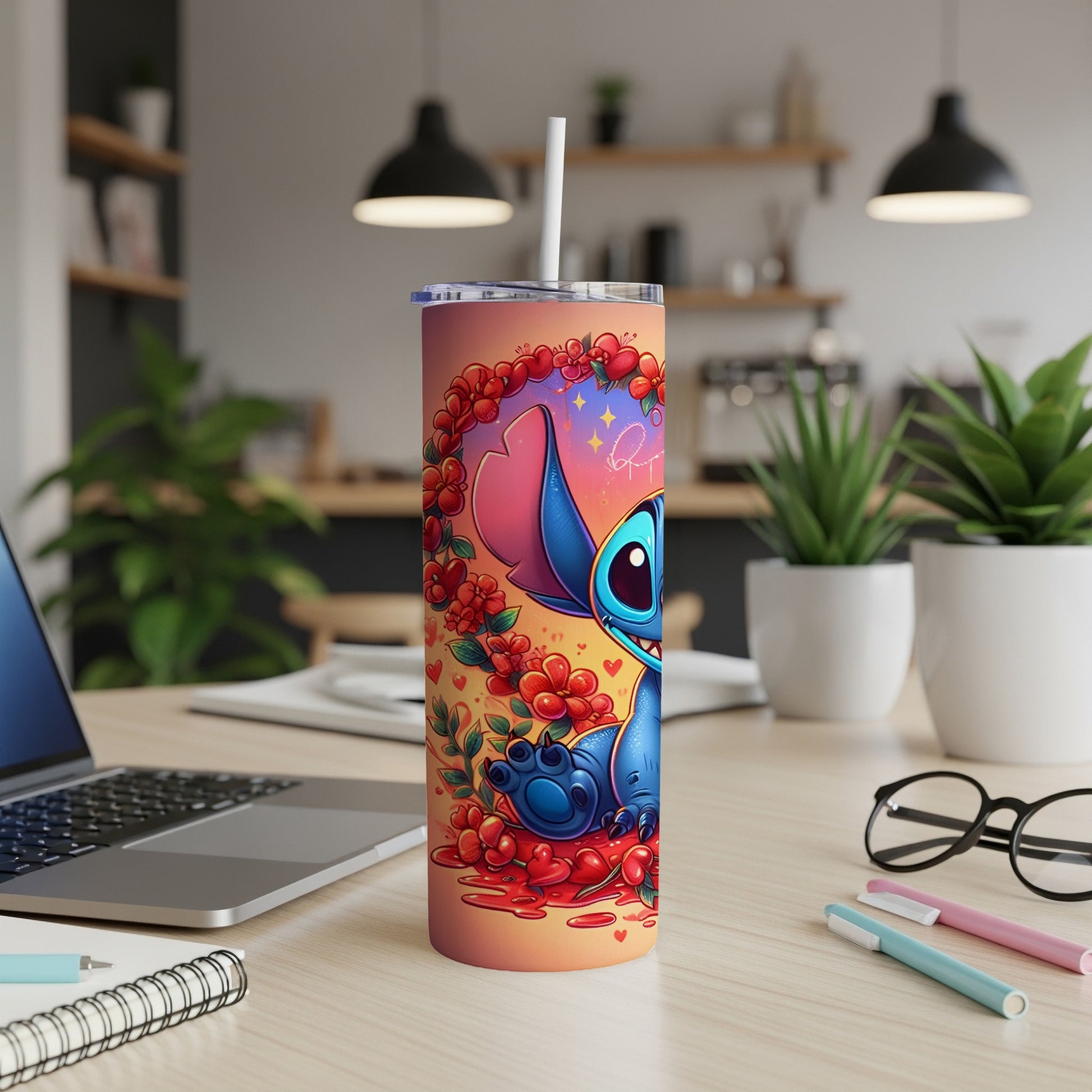 Stitch character on a floral patterned tumbler with straw on desk.