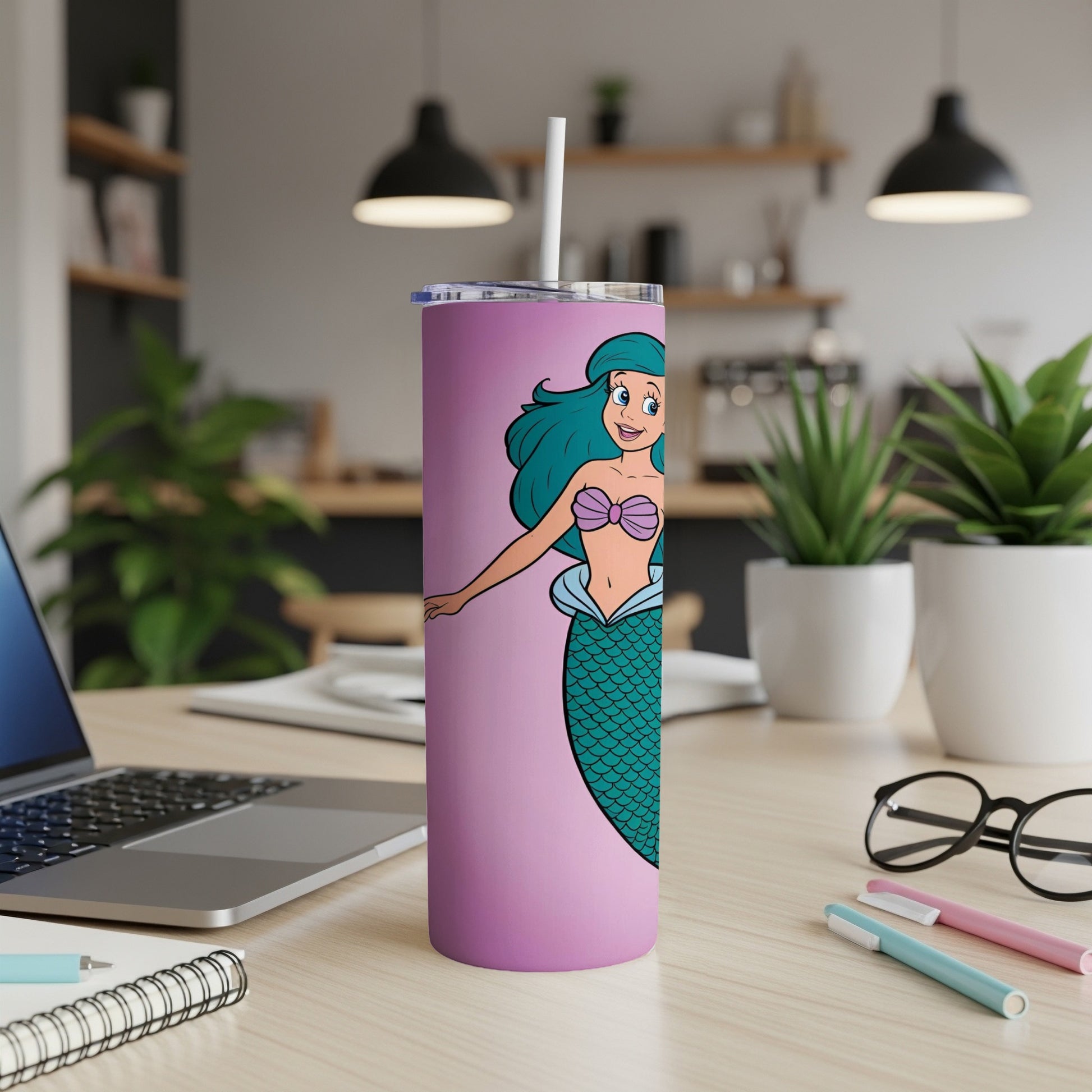 Pink tumbler with cartoon mermaid graphic and white straw.