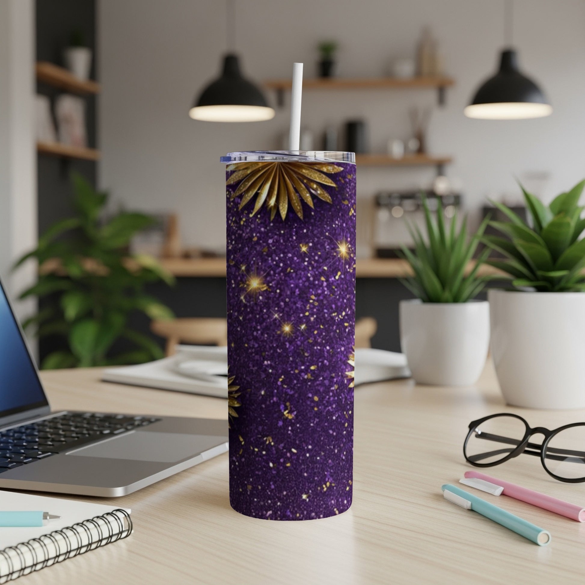 Purple tumbler with gold glitter and starburst design on desk.
