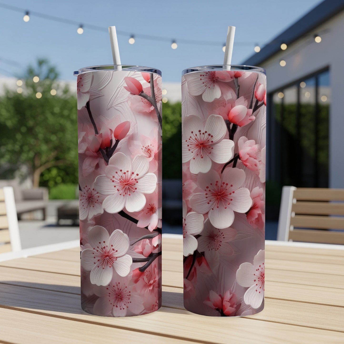 Two tumblers with pink cherry blossoms on a wooden table.