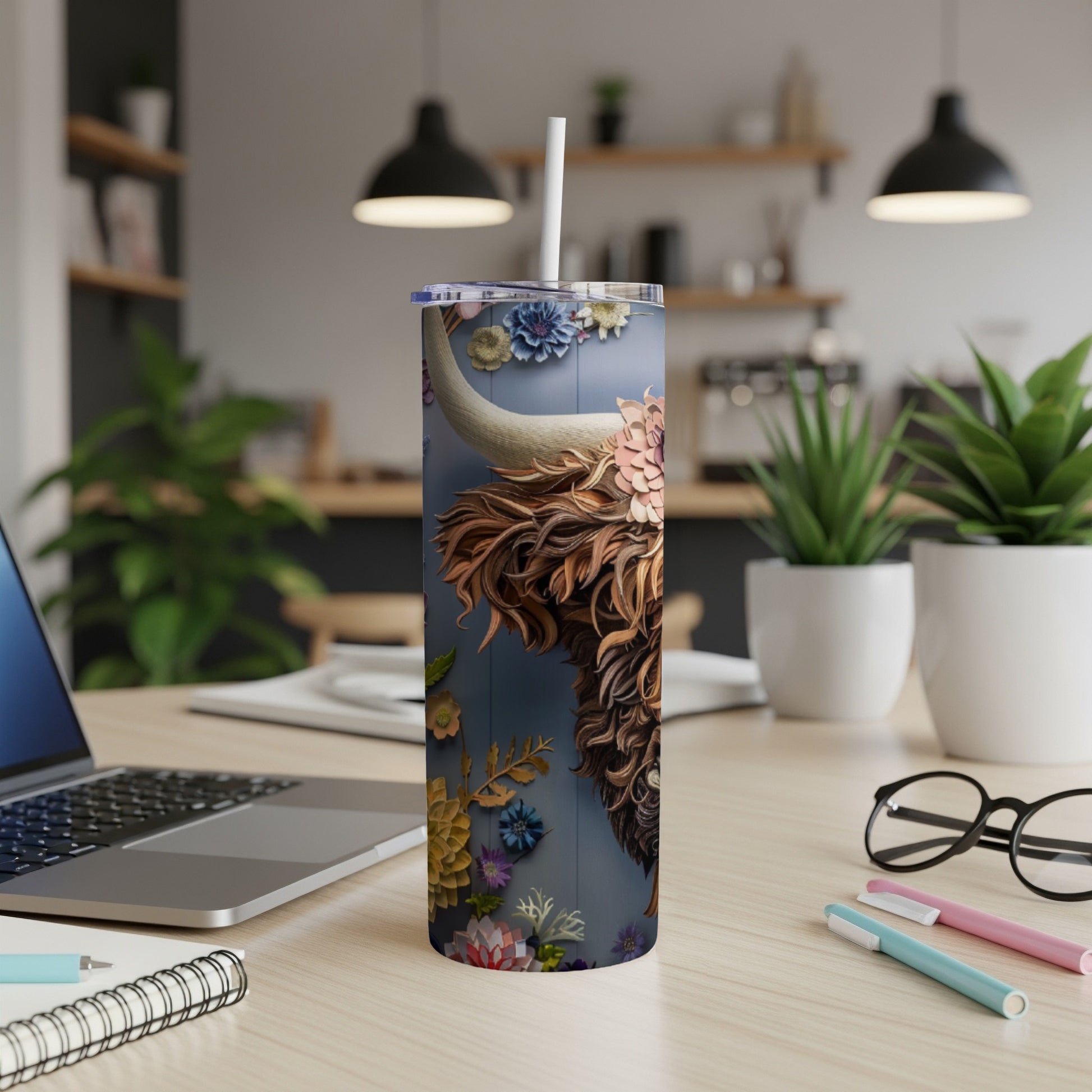 Tumbler featuring a detailed, floral-covered Highland cow portrait on a dark blue background.