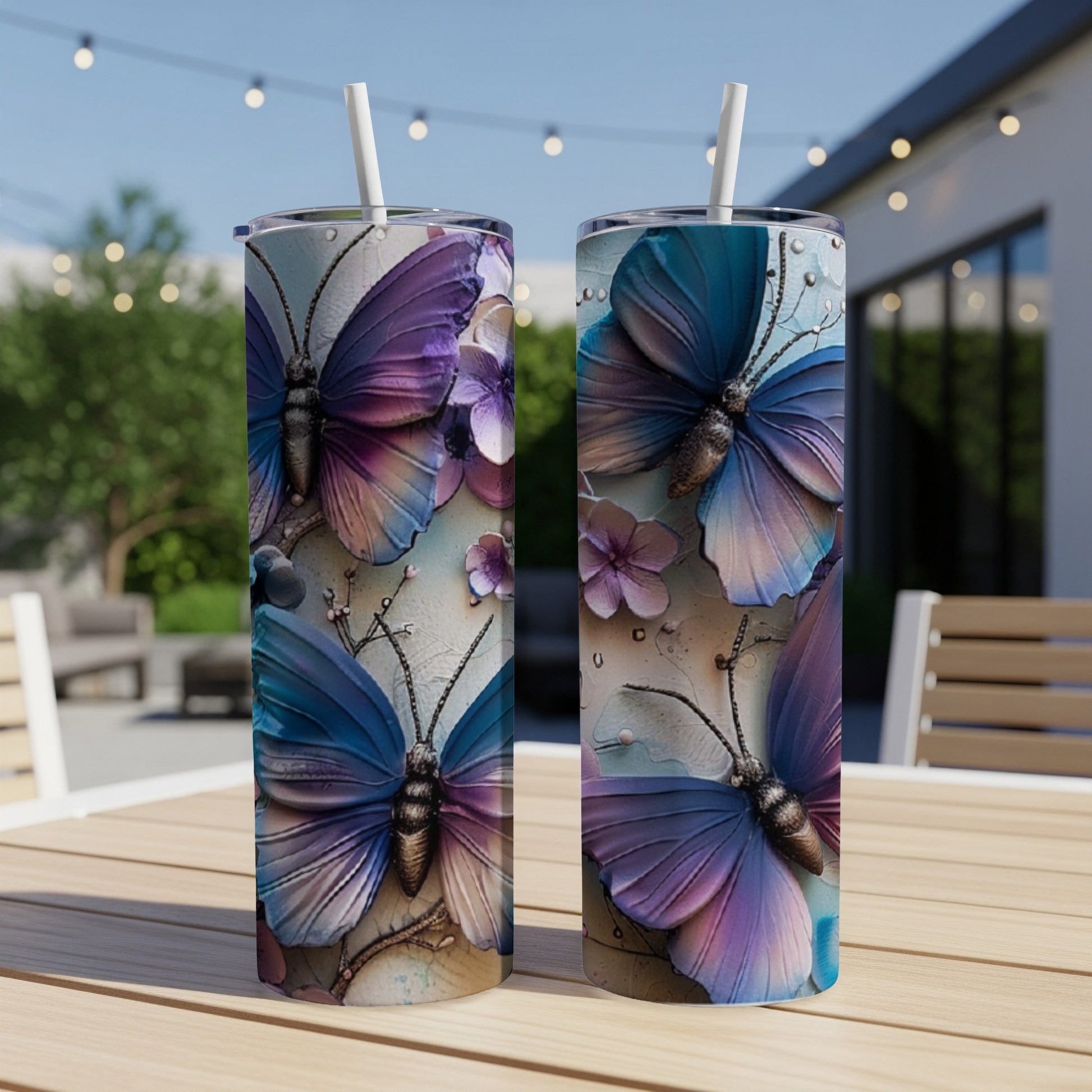 Two tumblers with purple and blue butterfly designs on a wooden table.