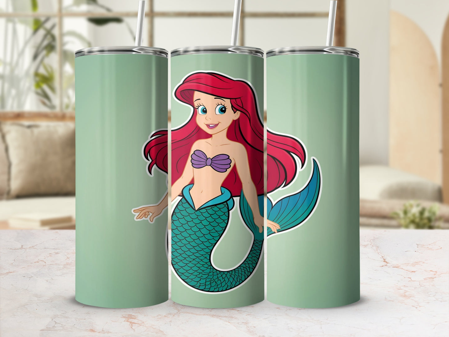 Ariel the mermaid with red hair and a teal tail on a mint green tumbler.