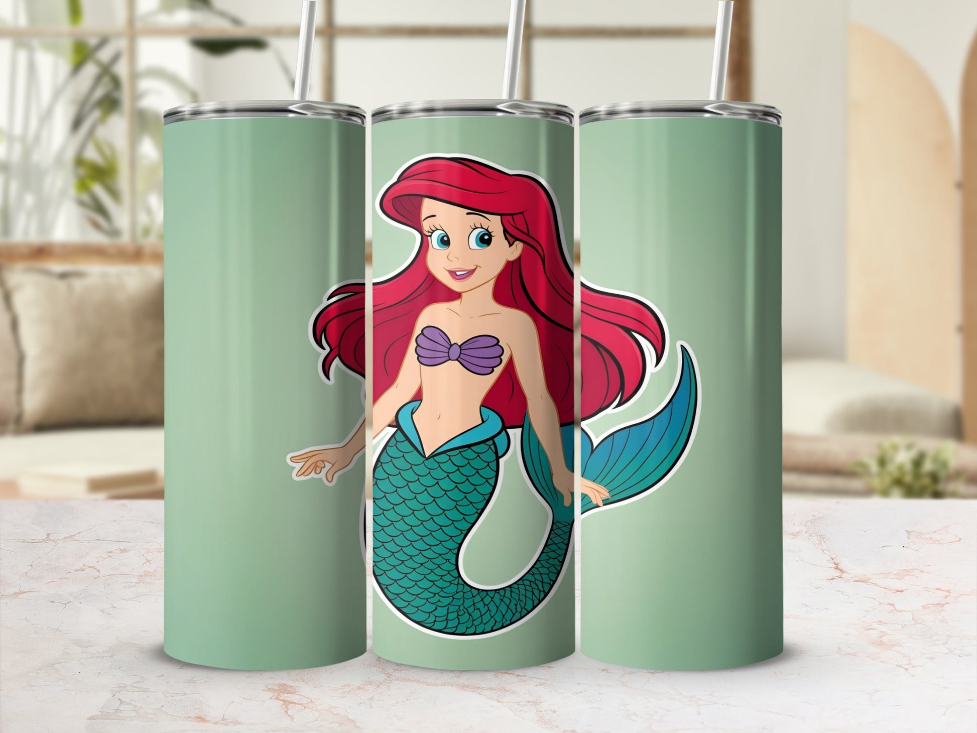 Ariel the mermaid with red hair and a teal tail on a mint green tumbler.