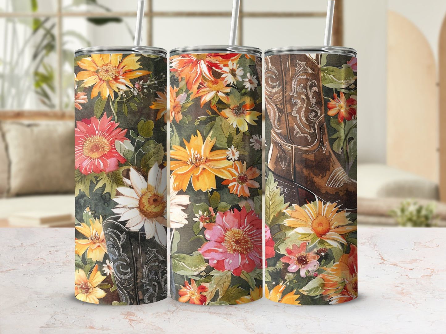 Floral cowboy boot tumbler with straw on marbled surface.